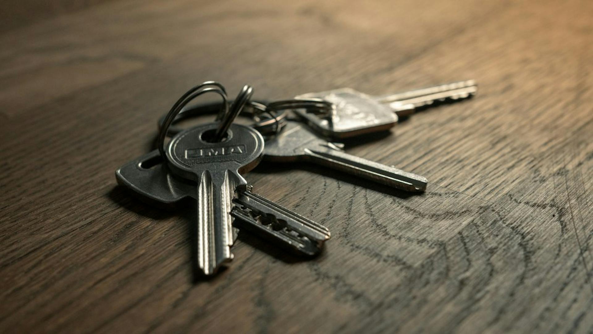 Set of keys lying on a wooden table (Photo by Filip Szalbot on Unsplash)