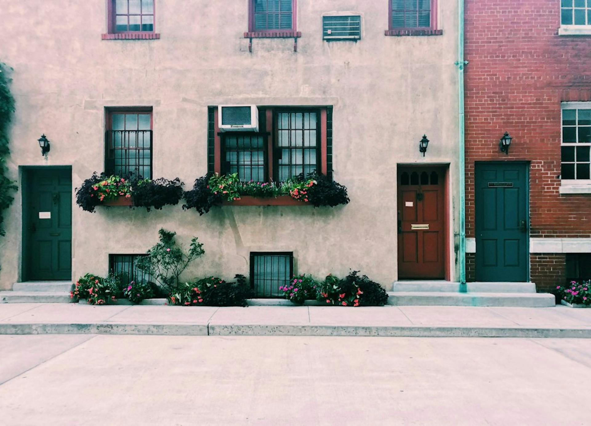 Row of townhouse doors with flower boxes under the windows (Photo by Anjali Mehta on Unsplash)