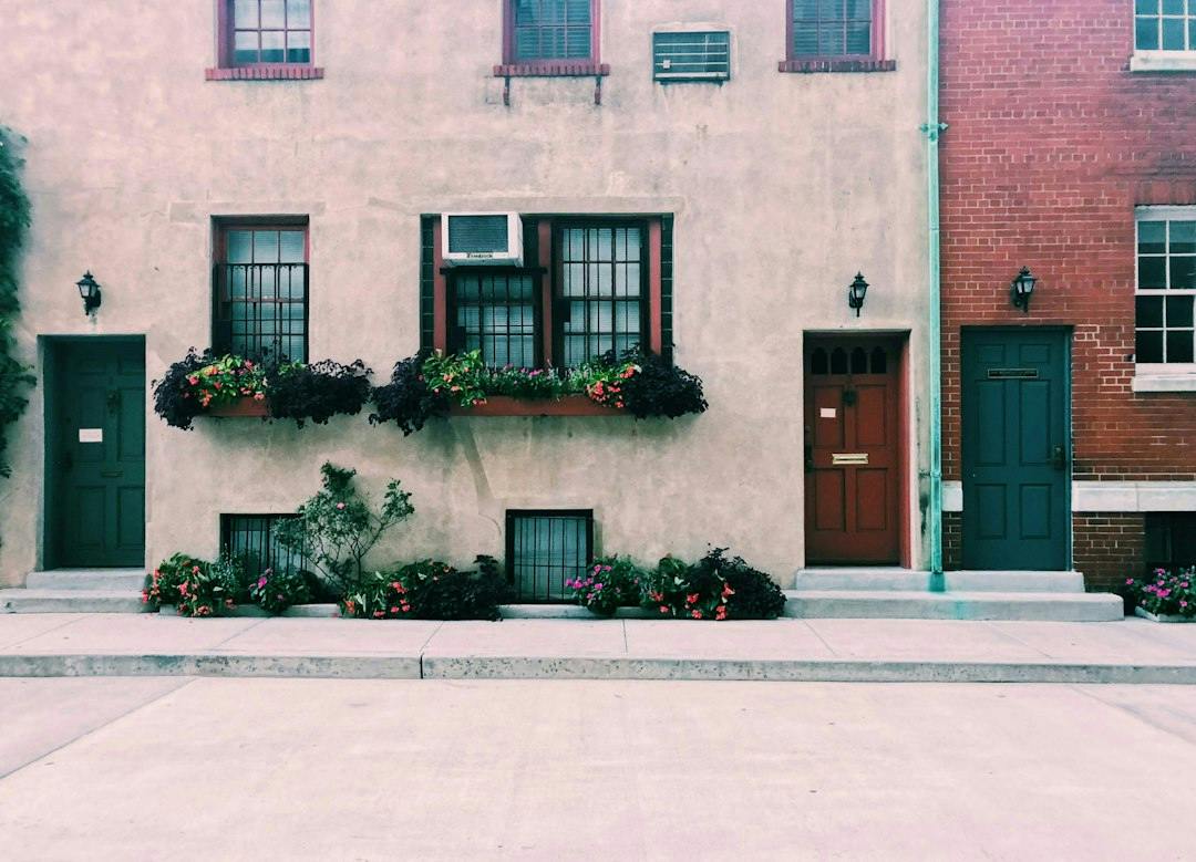 Row of townhouse doors with flower boxes under the windows (Photo by Anjali Mehta on Unsplash)