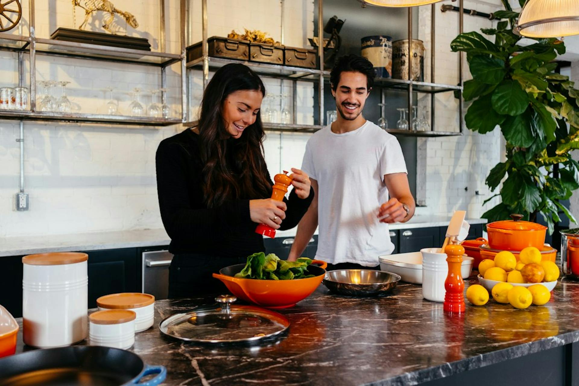 Young couple cooking together in a shared kitchen (Photo by Jason Briscoe on Unsplash)