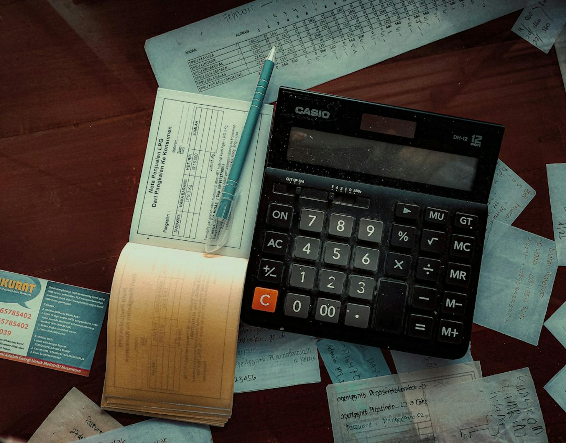Calculator and receipts spread on a table (Photo by FIN on Unsplash)