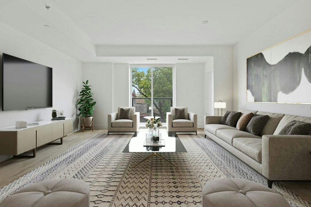 Bright living room with a grey sofa and large windows (Photo by Point3D Commercial Imaging Ltd. on Unsplash)