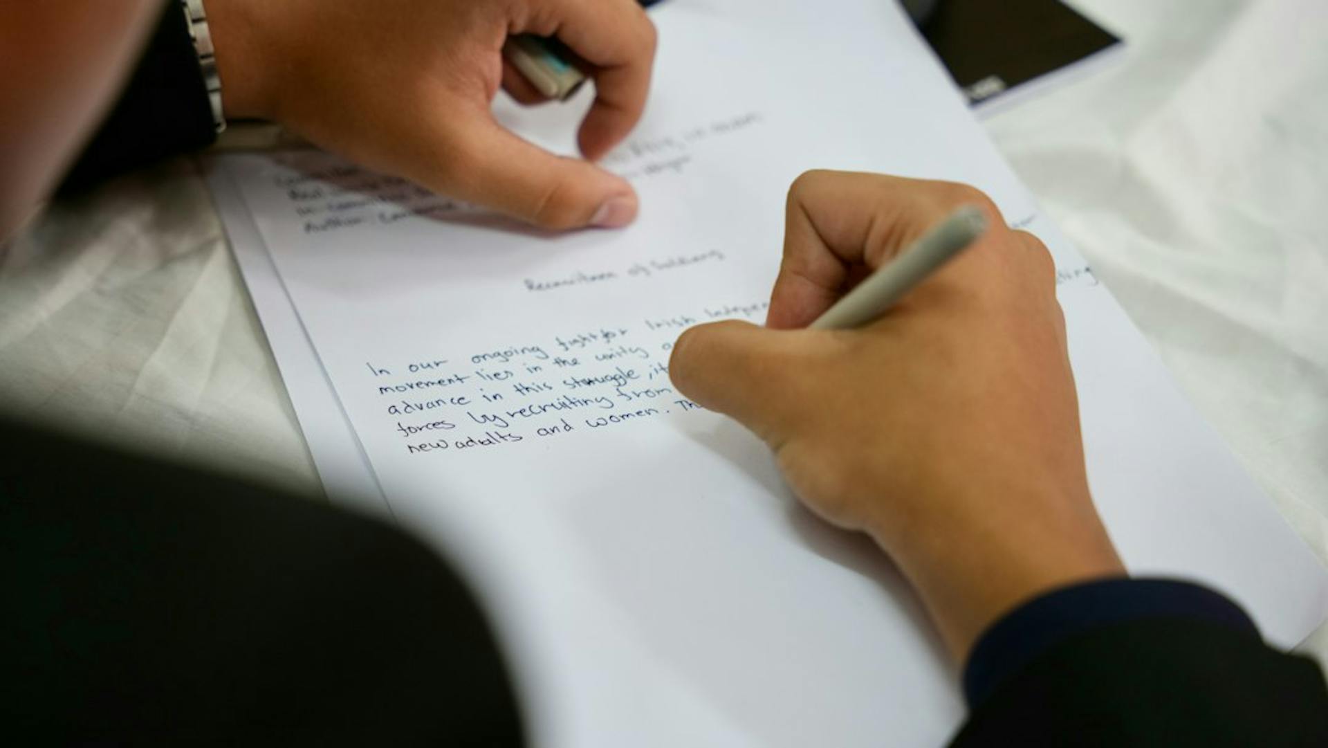Person filling in a paper form with a pen (Photo by Ojus Jaiswal on Unsplash)