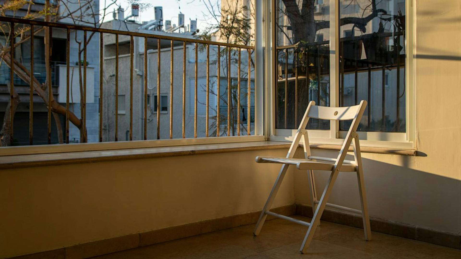 Folding chair in a sunny room with a balcony door (Photo by Daniel Lerman on Unsplash)