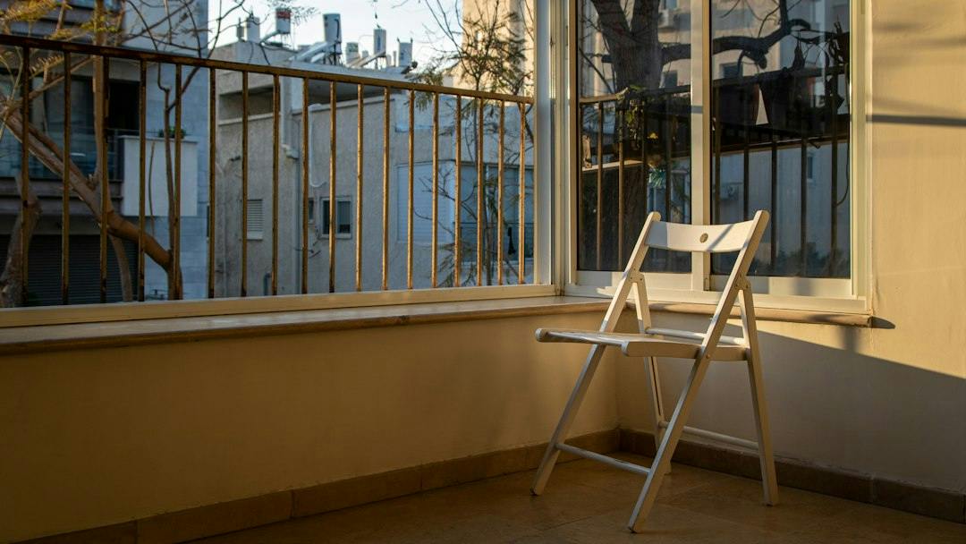 Folding chair in a sunny room with a balcony door (Photo by Daniel Lerman on Unsplash)