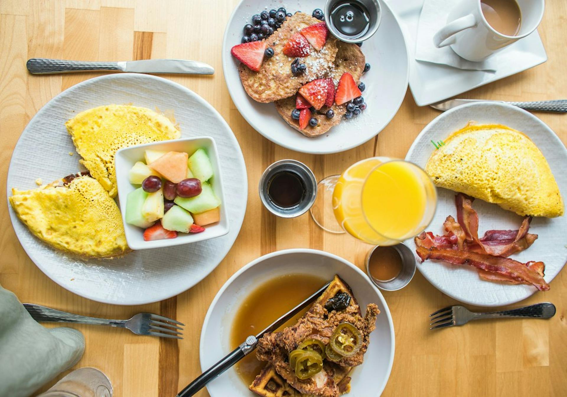 Morgenmadstallerkener med omelet, frugt og kaffe på et fælles bord (Photo by Heather Ford on Unsplash)