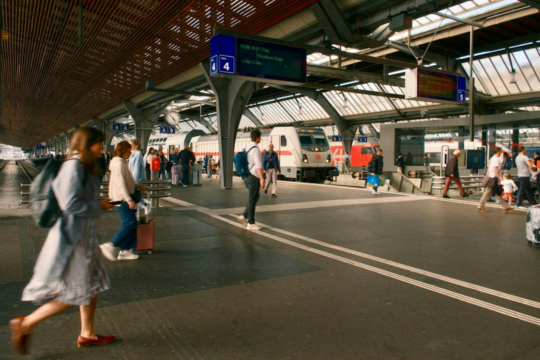 Travellers walking along a busy train station platform (Photo by Bryan Dijkhuizen on Unsplash)