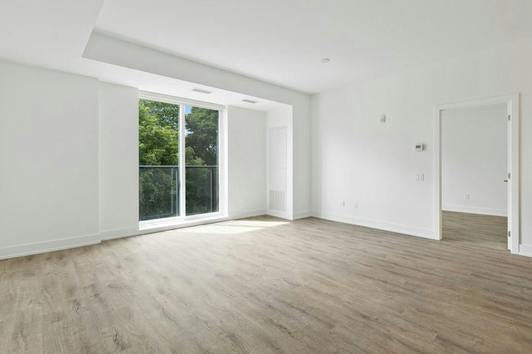 Empty bright living room with a balcony door (Photo by Point3D Commercial Imaging Ltd. on Unsplash)