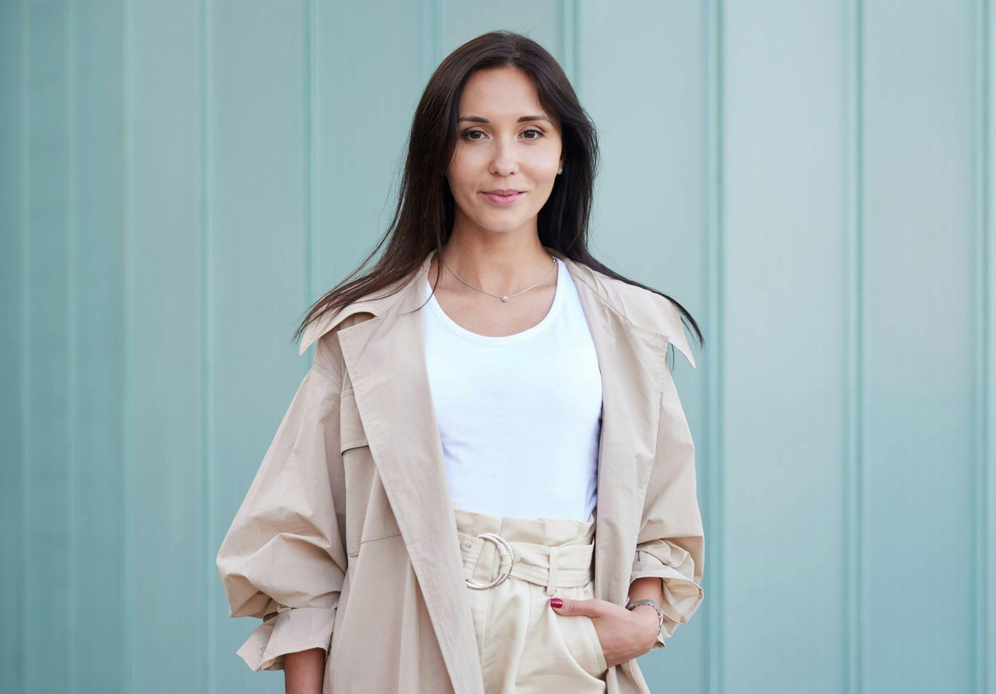 woman in a white top and long beige coat