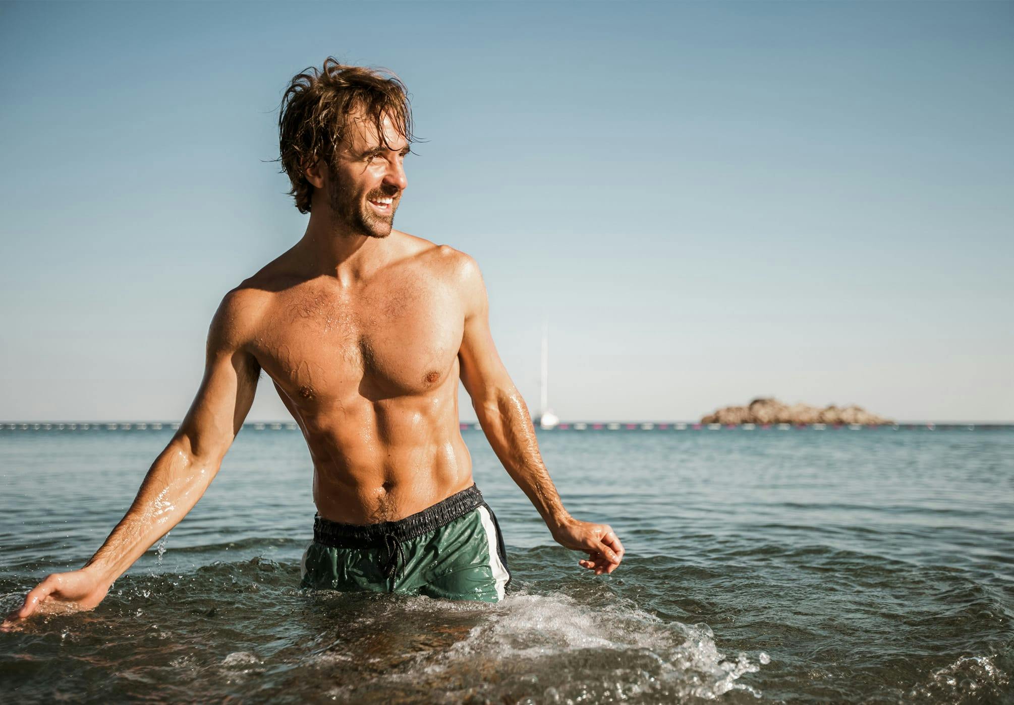 man with toned abs in the ocean