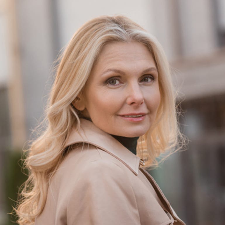 woman with blonde hair wearing a coat