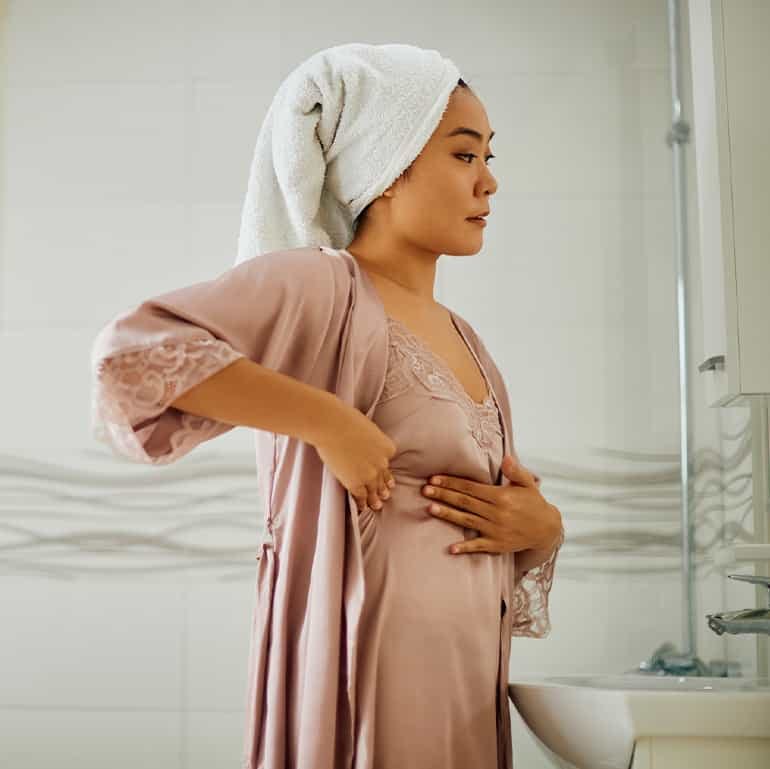 woman performing a breast exam at home