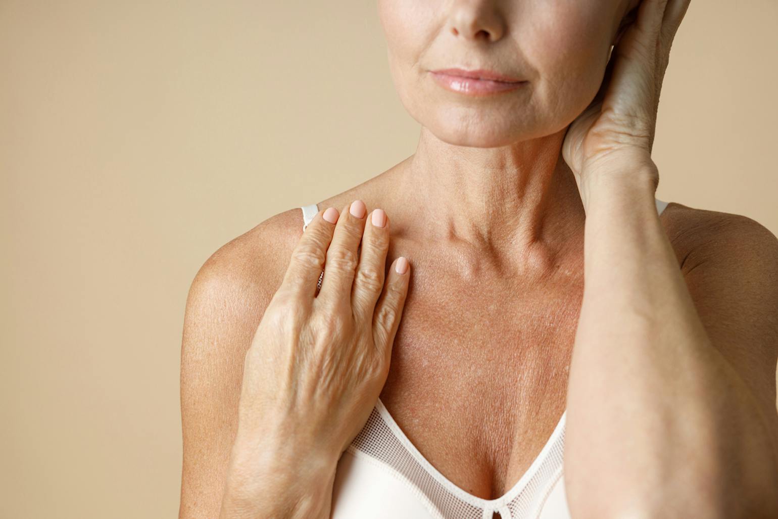 Older woman in bra touching her neck