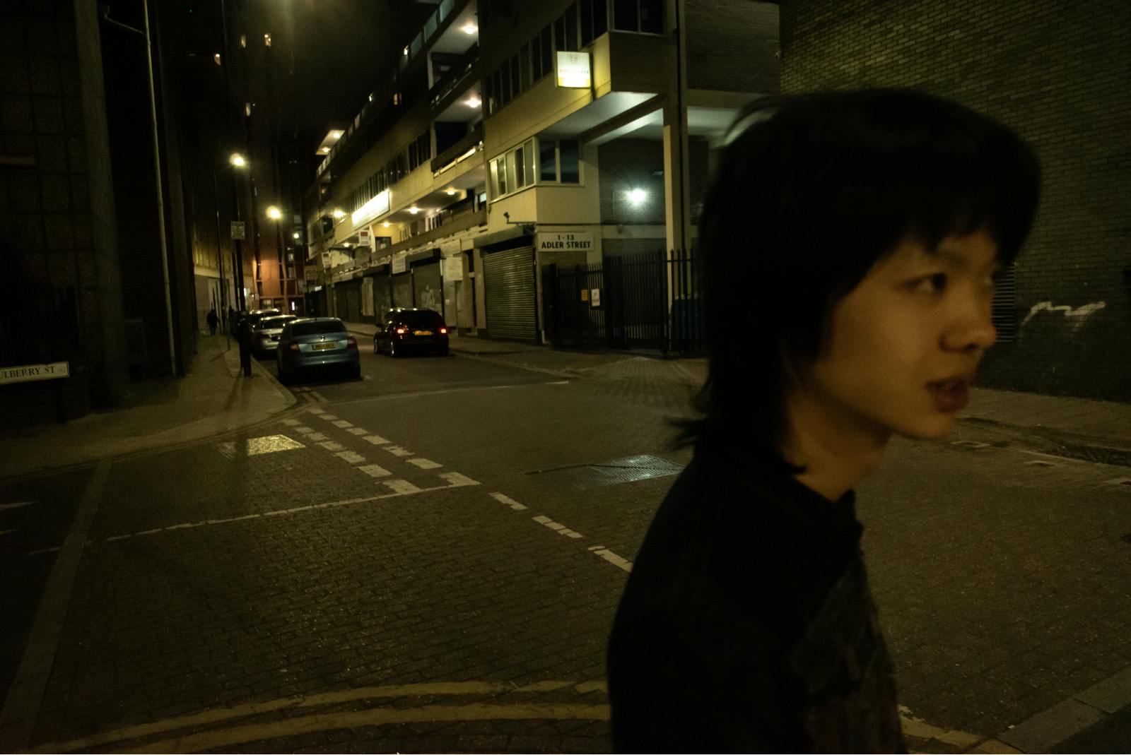 Mlad moški v profilu na ulici ponoči.