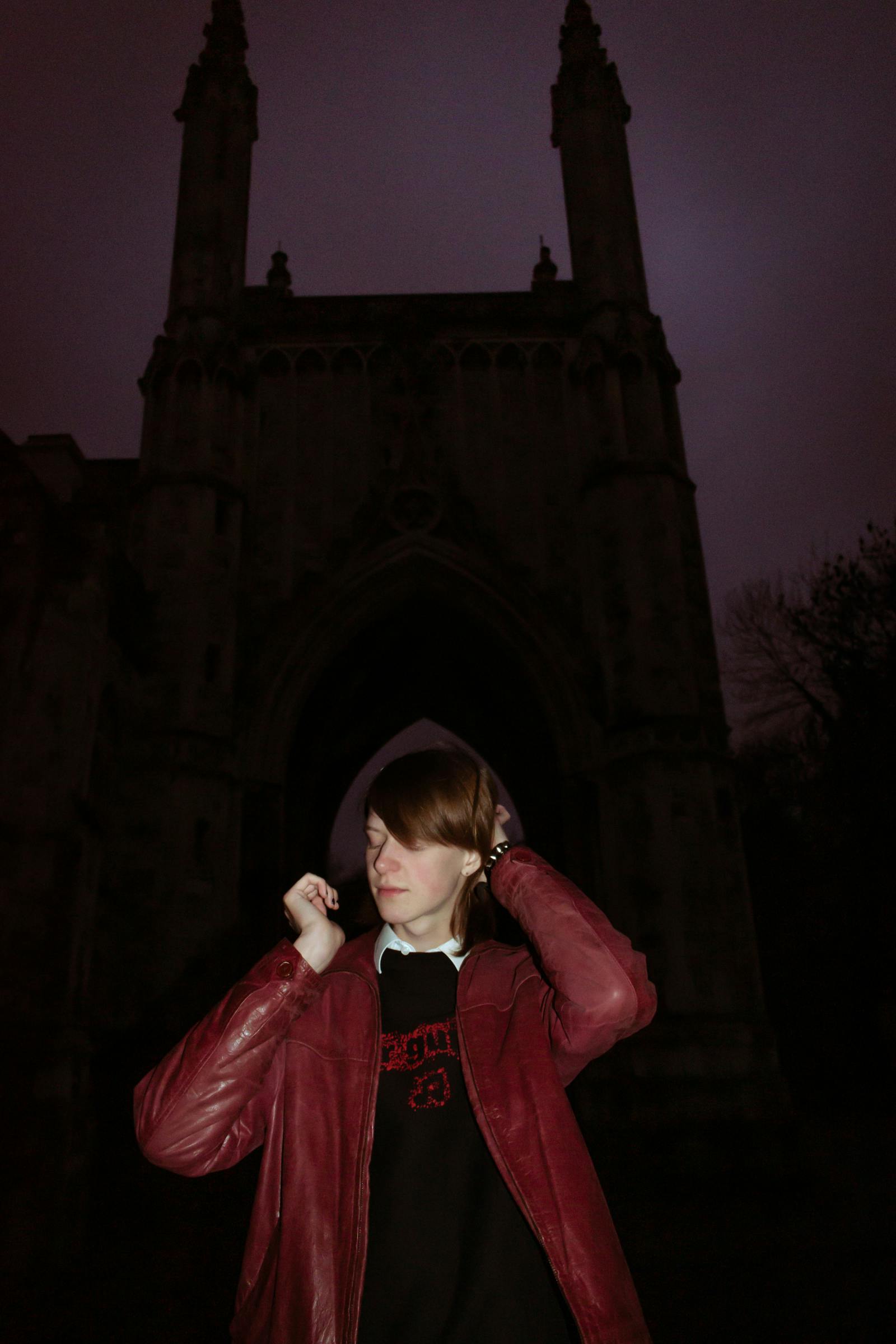 Mlad moški pred cerkvijo v nočnem pejsažu.