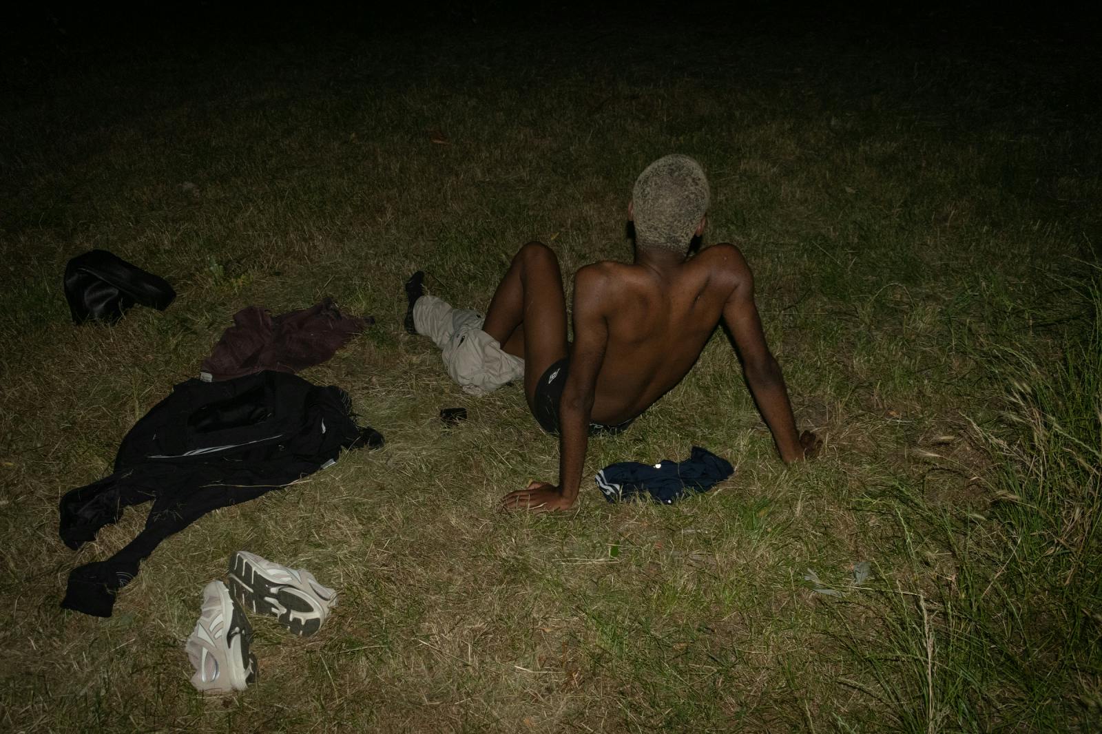 Mlad moški na trati sredi noči.