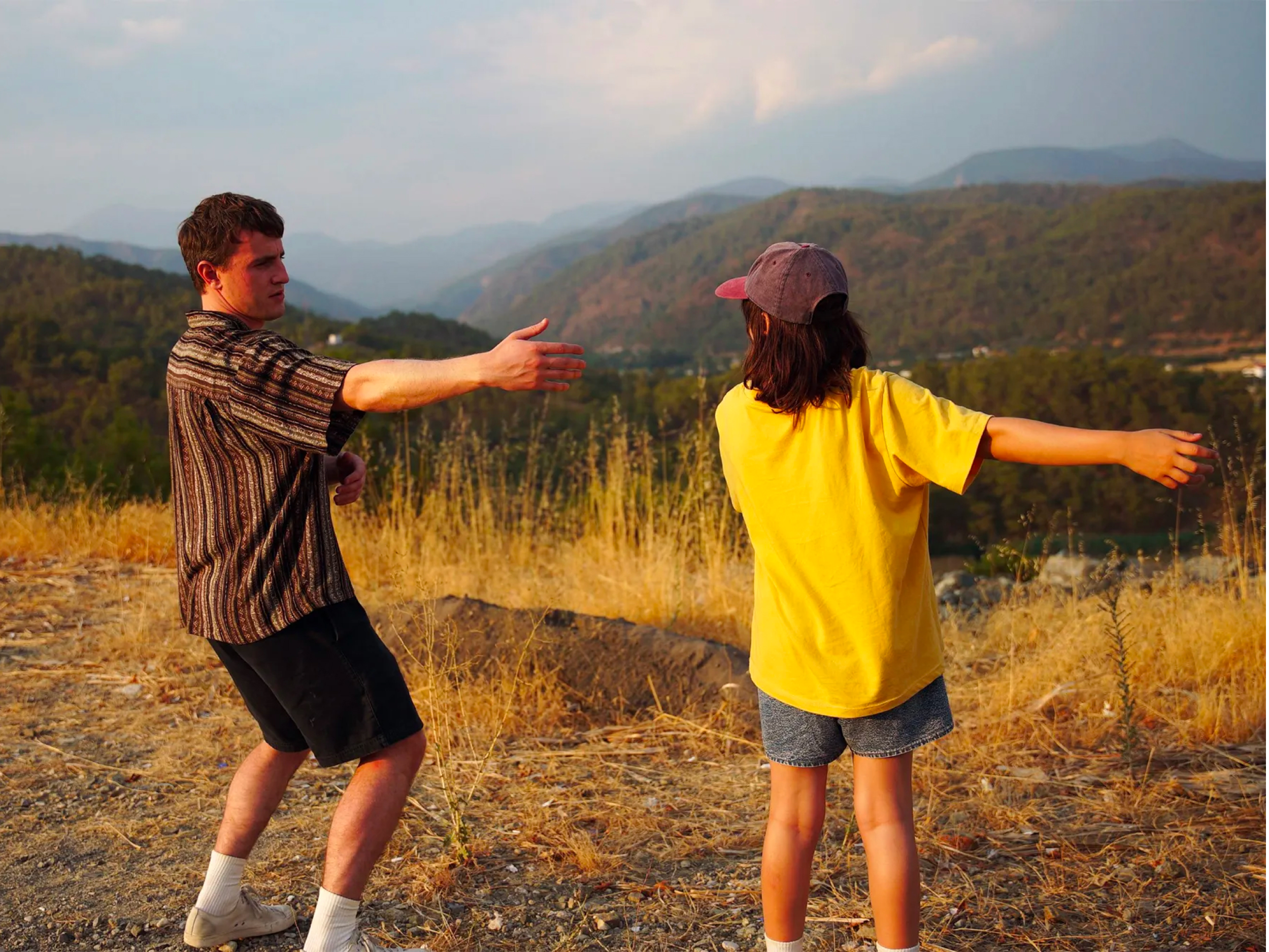 Mlad fant na vrhu griča vabi punco k plesu.