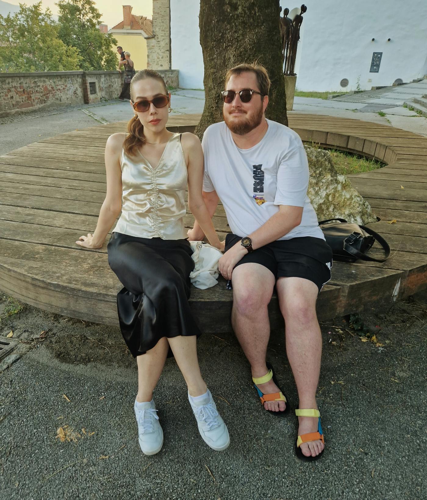 Fotografija avtorjev pogovorov v prispevku, sedita zunaj ob drevesu in pozirata