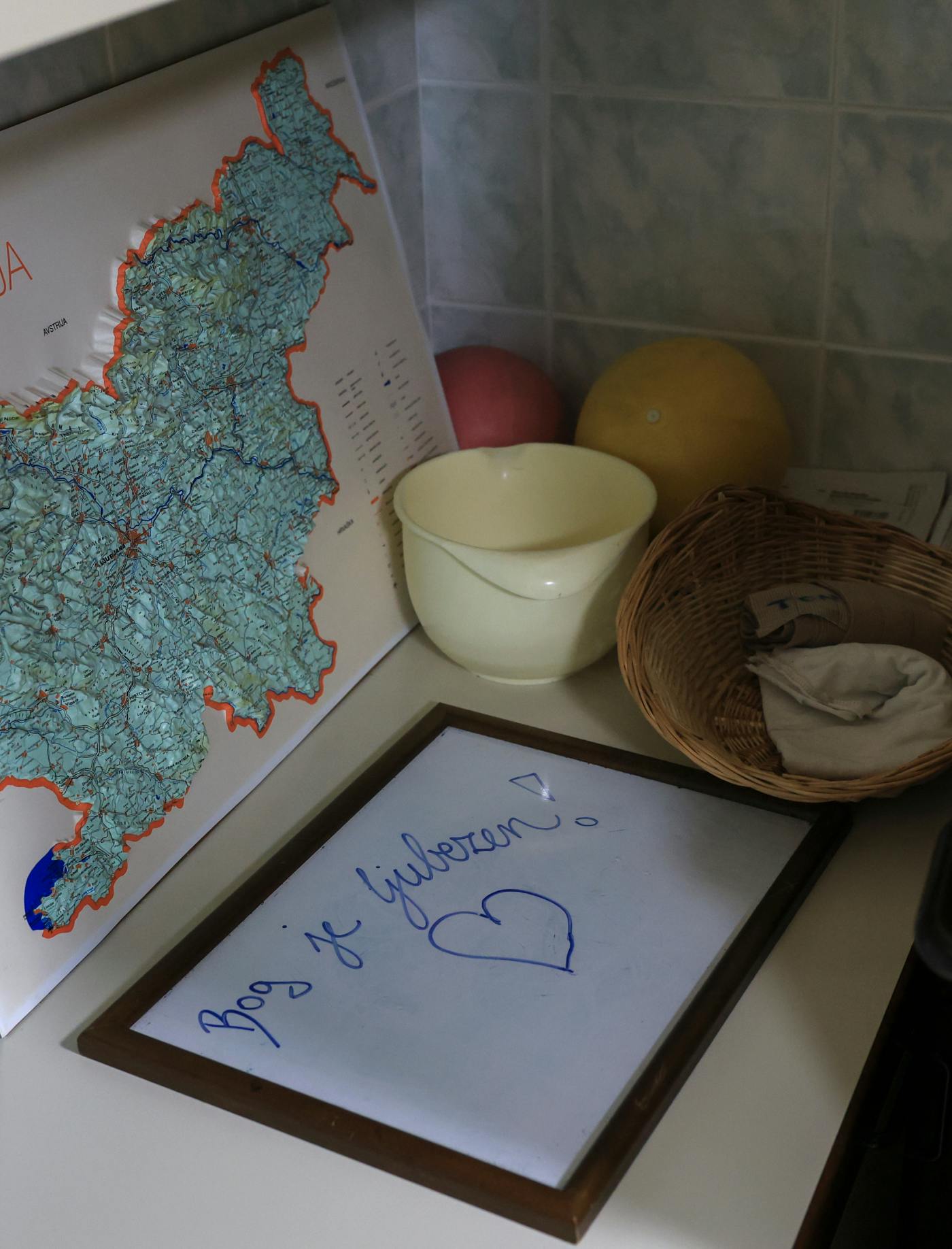 Miza, na njej košara, zemljevid Slovenije in tabla z napisom Bog je ljubezen
