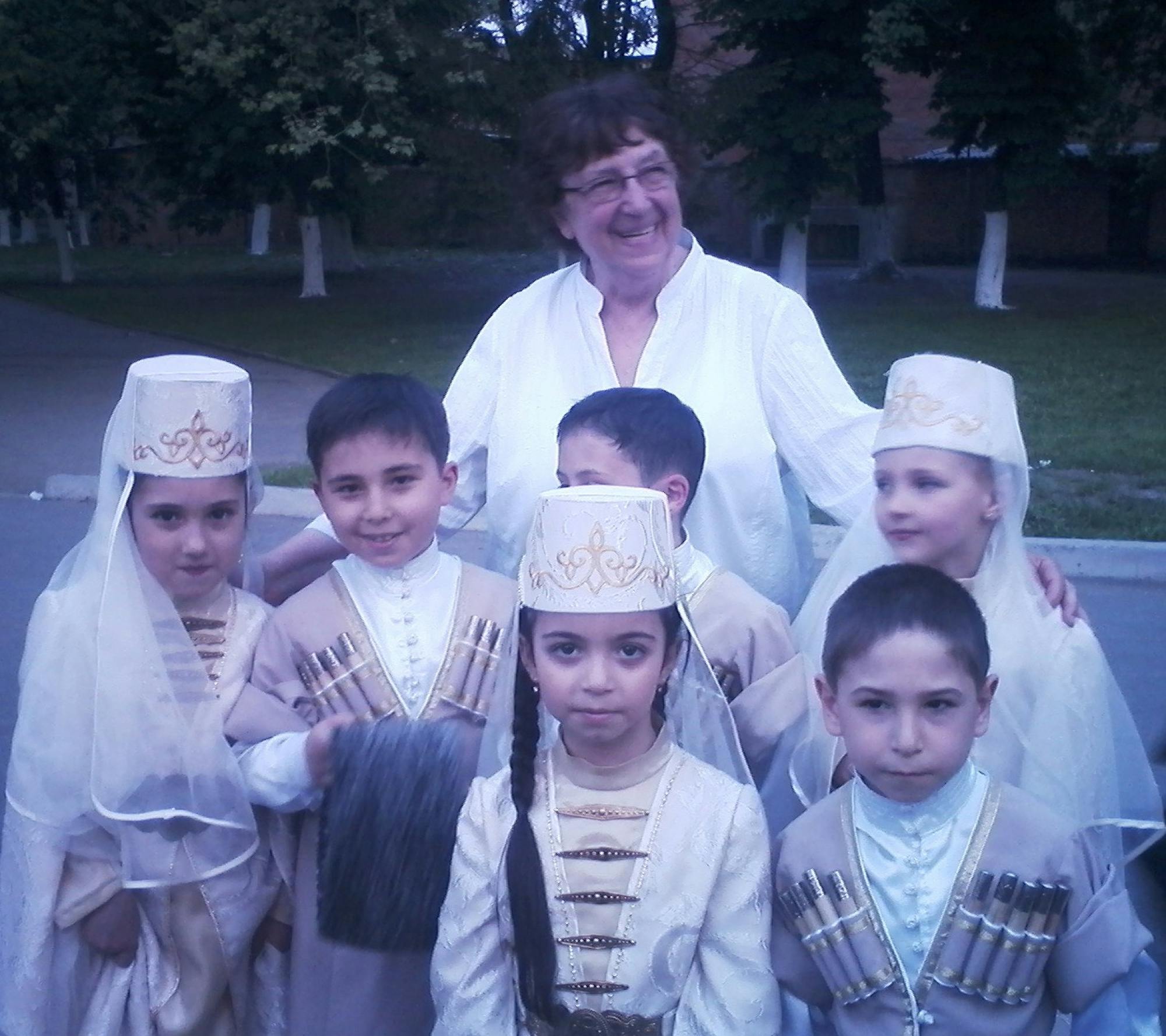 dr. Mikuš Kos s skupino šestih otrok v nošah