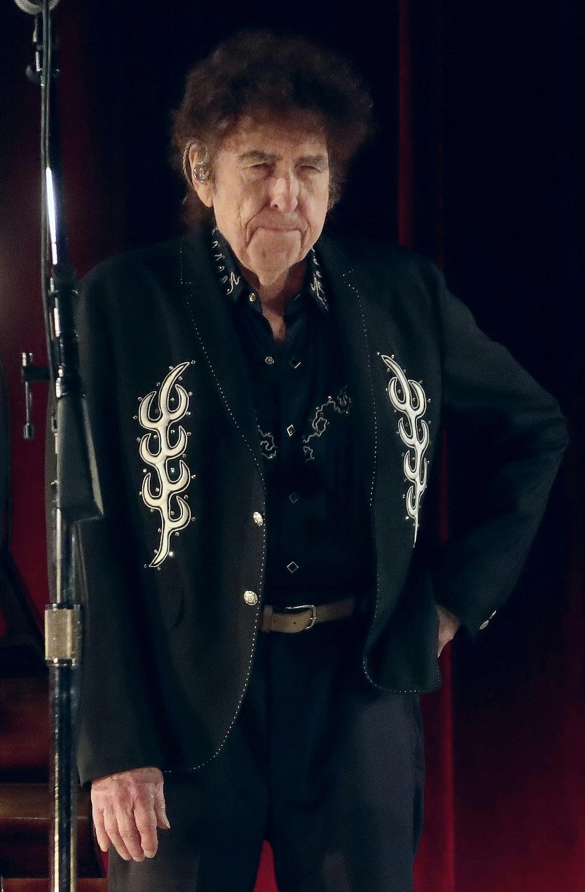 Dylan stoji na odru, zraven mikrofona