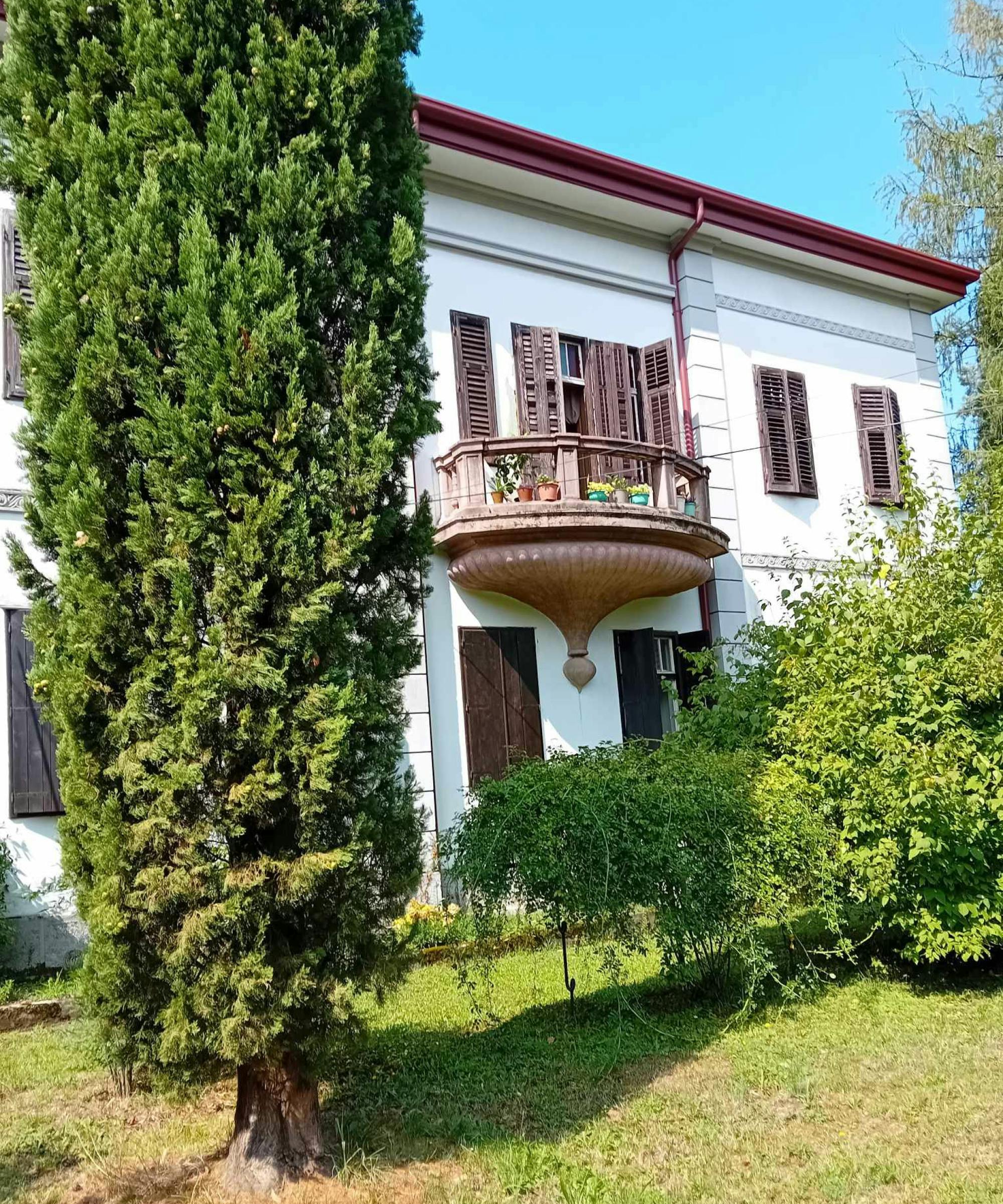 Večja bela hiša s polkrožnim balkonom