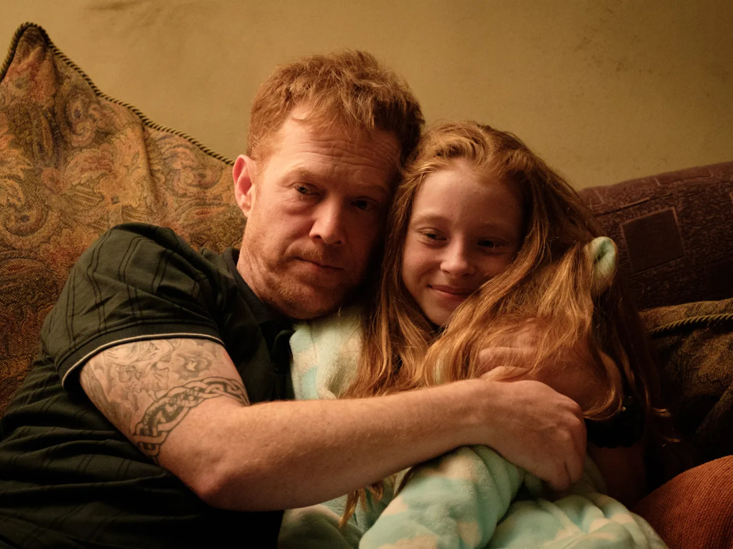 Moški objema mlajšo dekle (svojo hčerko).