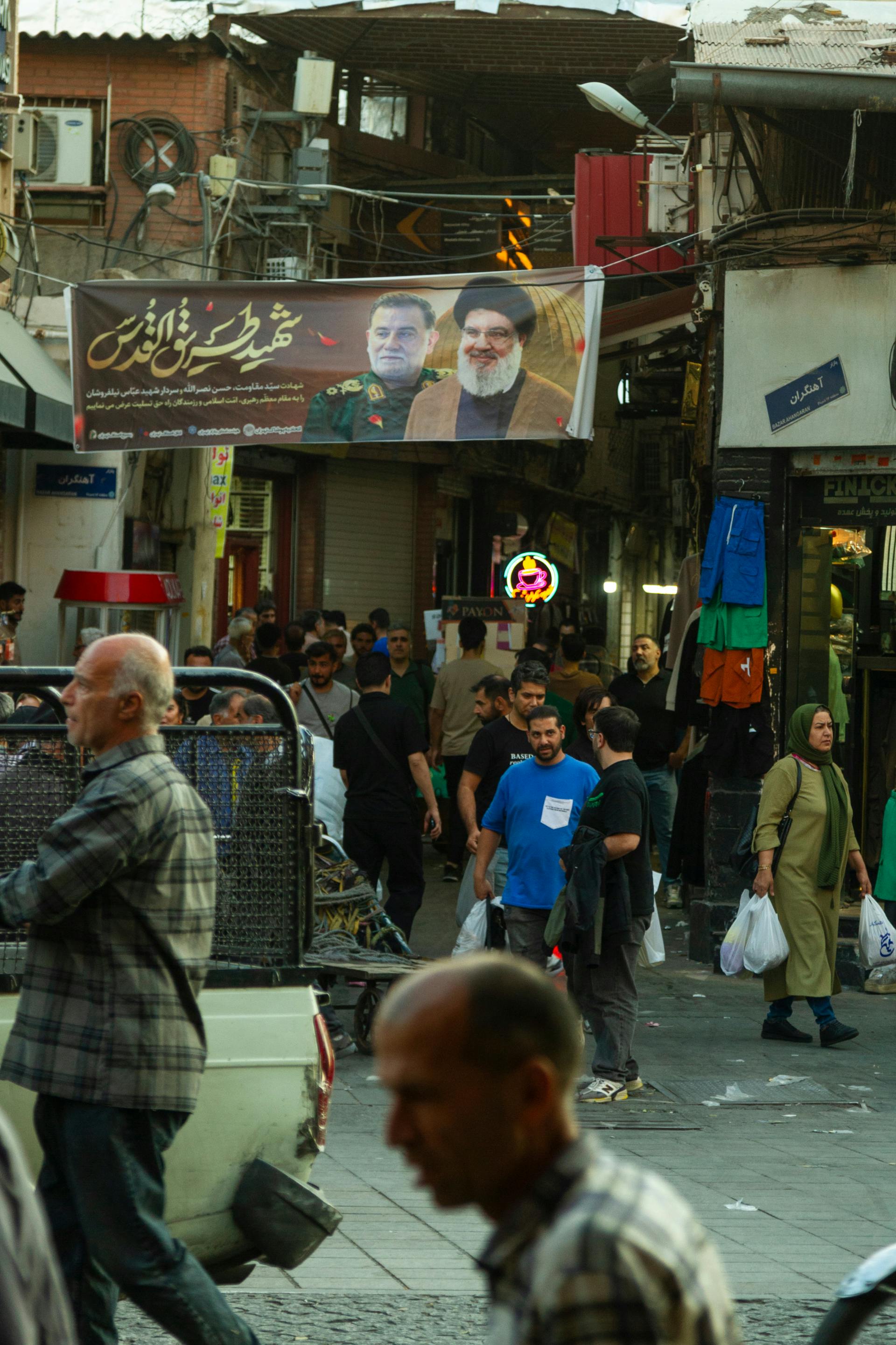 Iranska ulica z veliko ljudi in plakati vodij