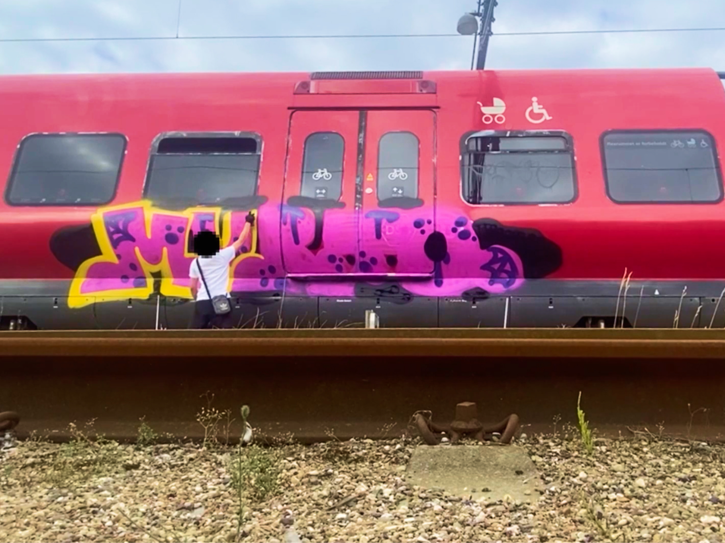 Cenzuriran moški, ki grafitira vlak