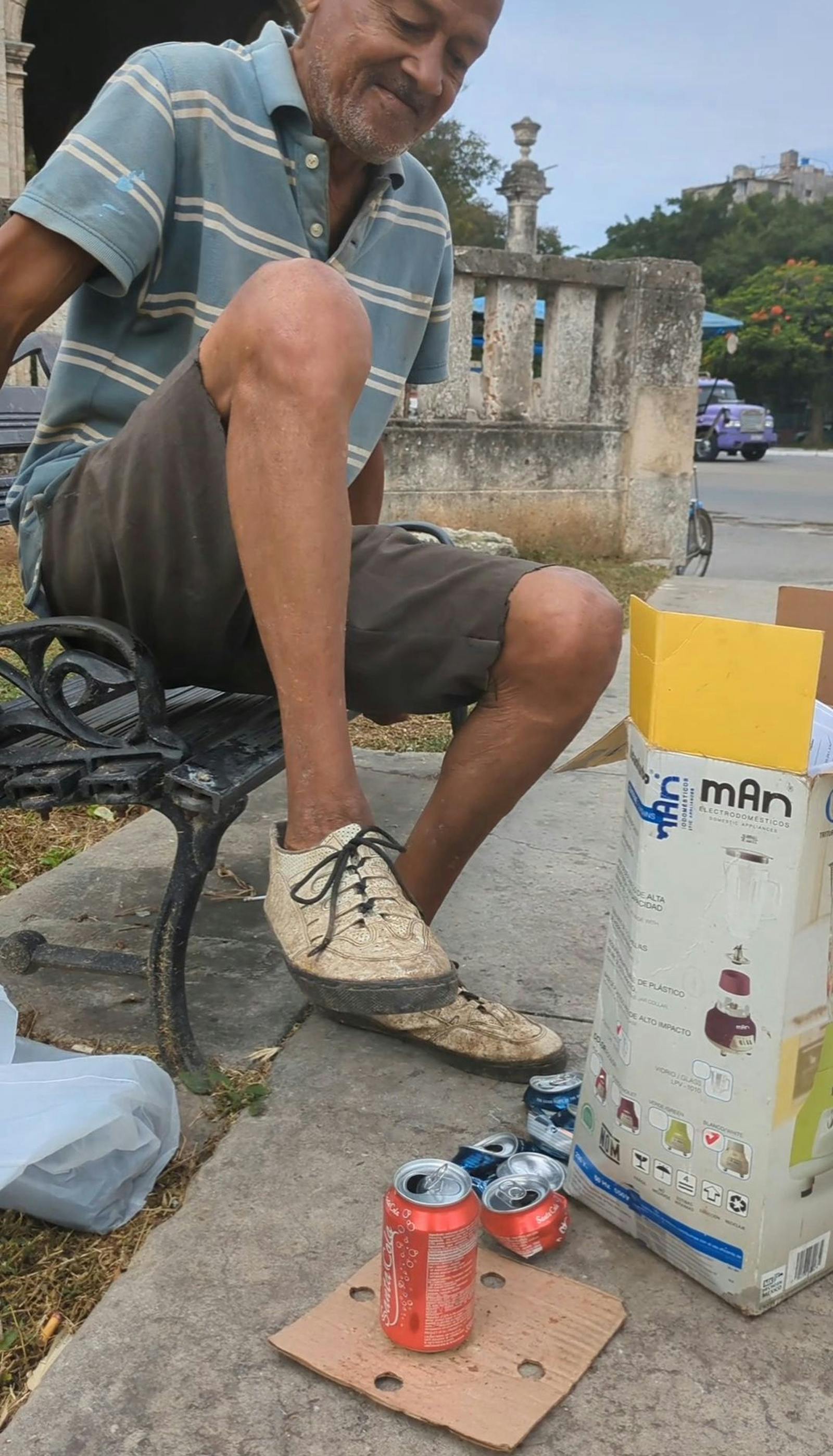 Moški, ki drobi prazne pločevinke z nogo
