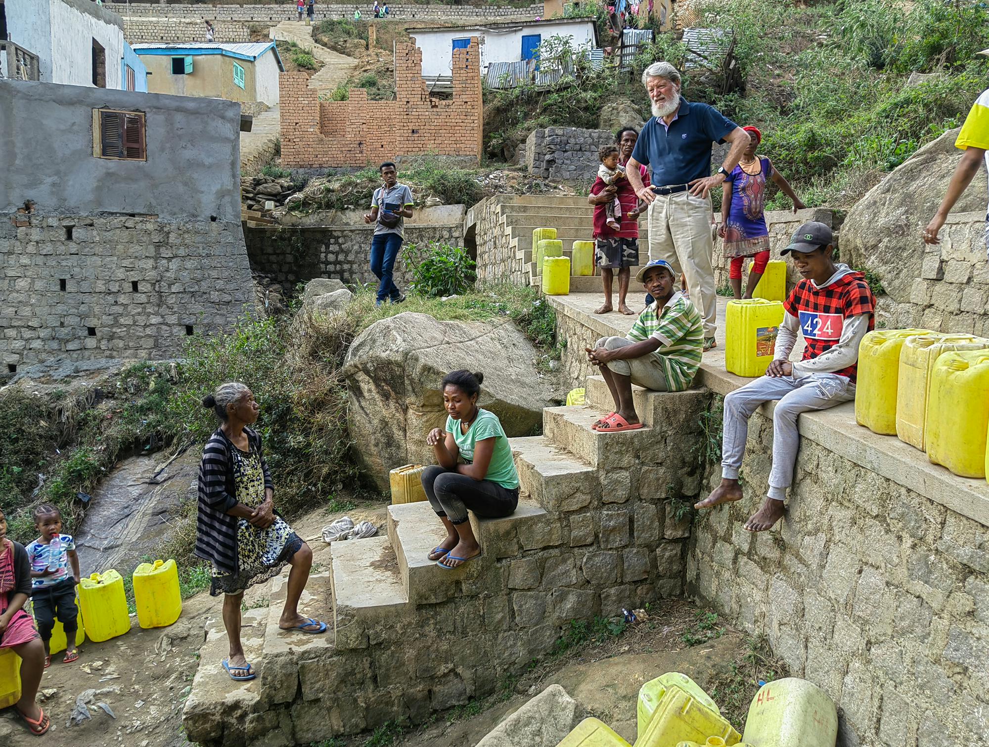 Pedro Opeka in domačini Madagaskarja med več kanistri za vodo