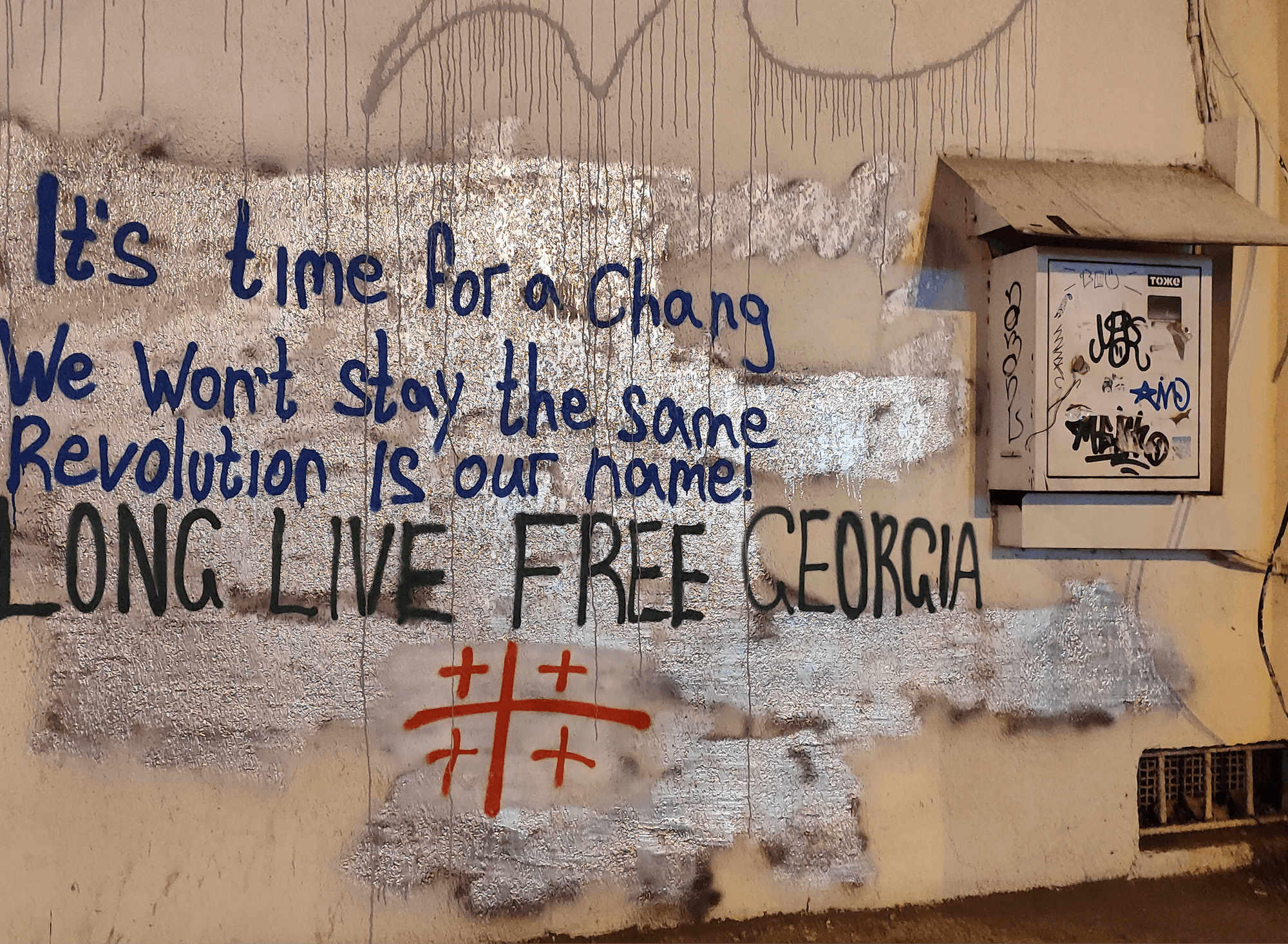 Grafit z napisom: It's time for a change, we won't stay the same, revolution is our home, long live free Georgia
