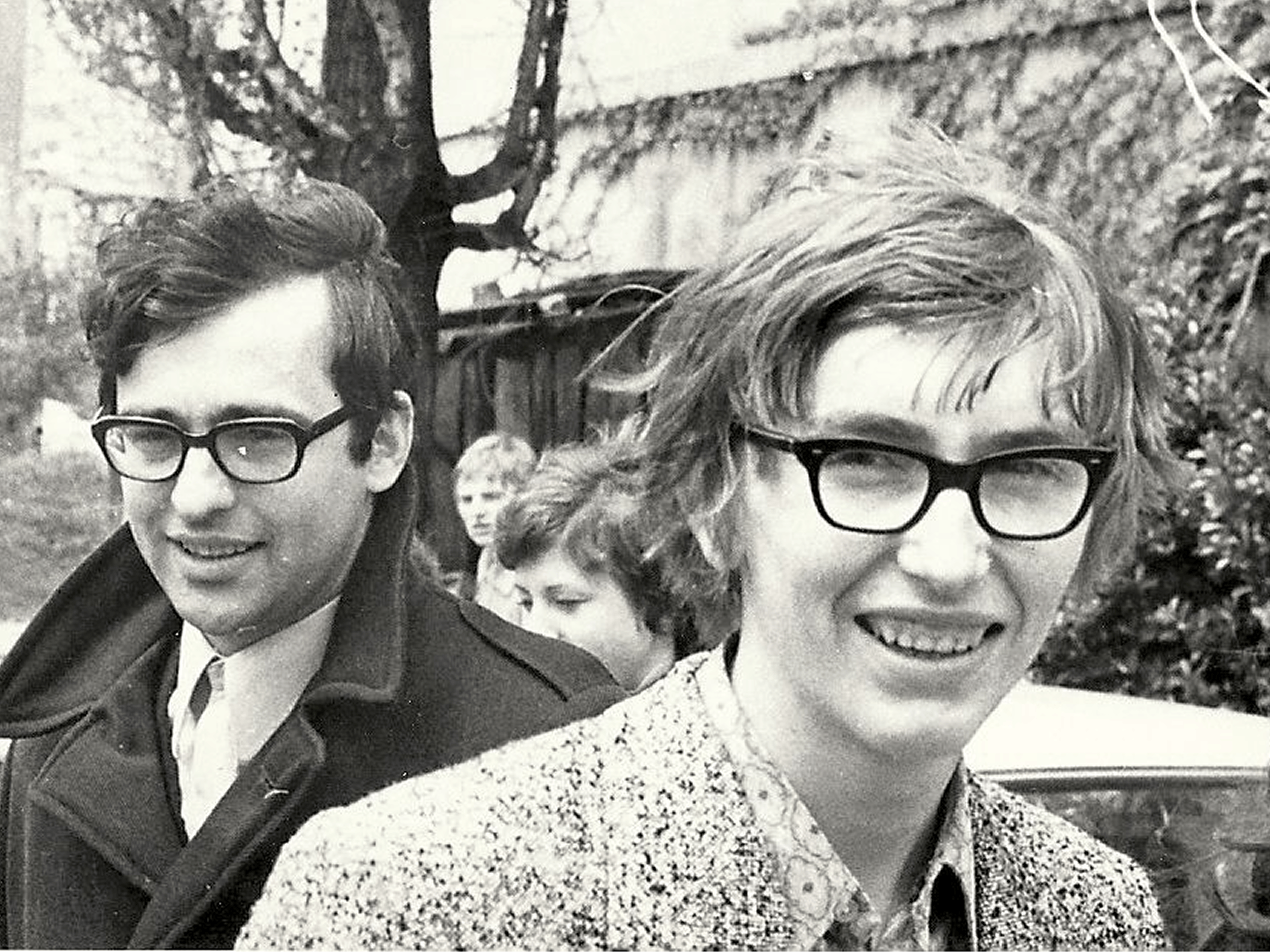 Stara črno-bela fotografija dveh nasmejanih mladih moških z očali