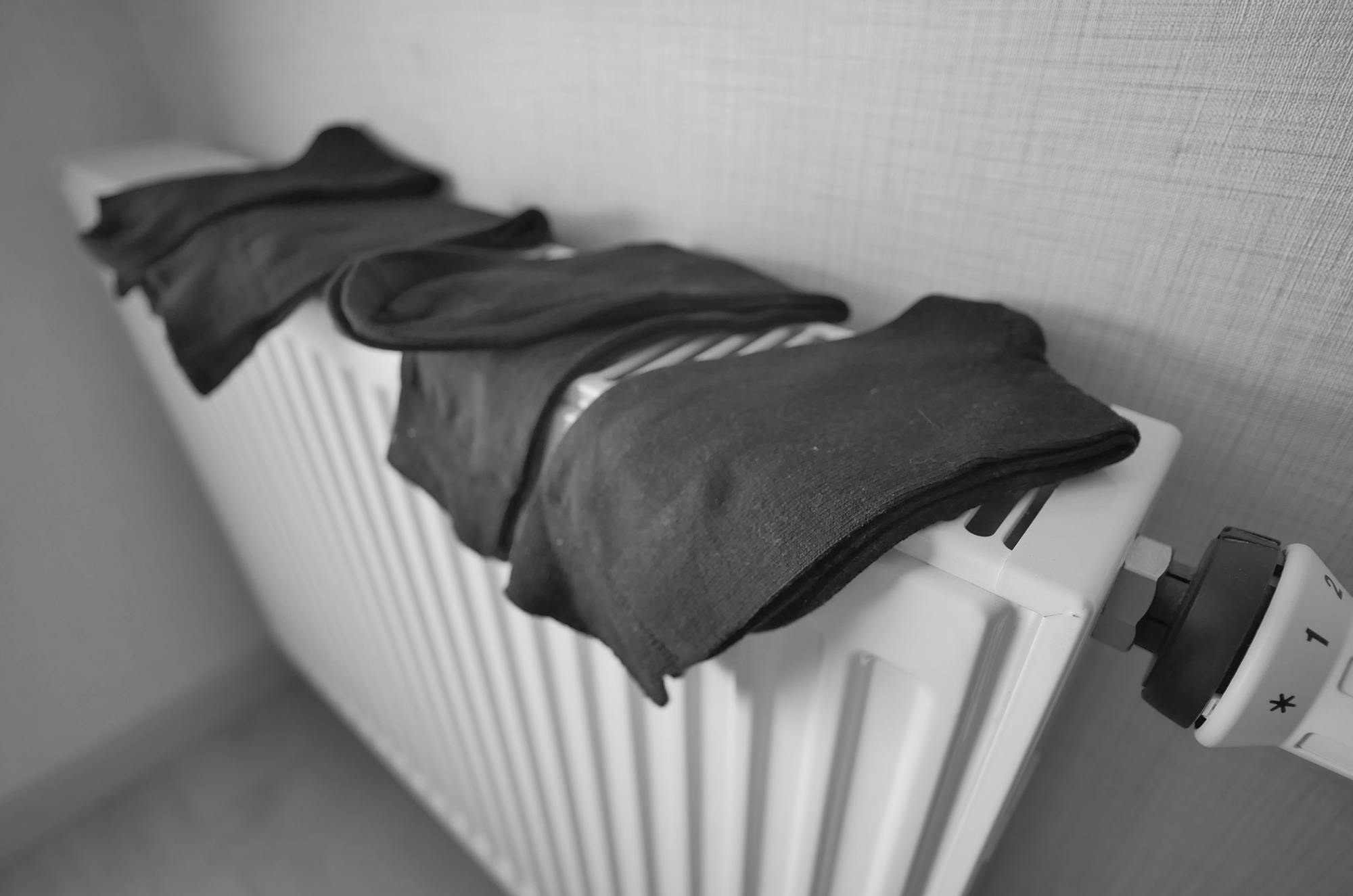 Črno-bela fotografija nogavic na radiatorju