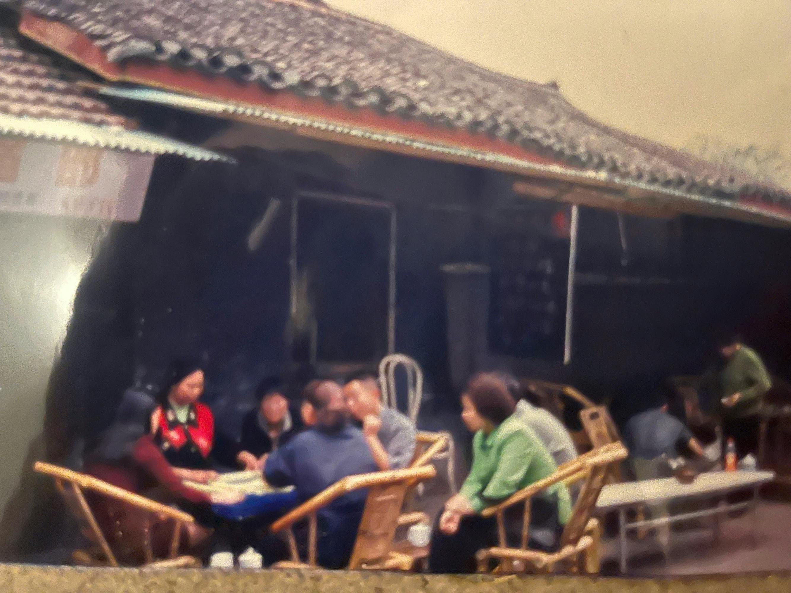 Ljudje v Chengdu, ki sedijo za mizo pred hišo