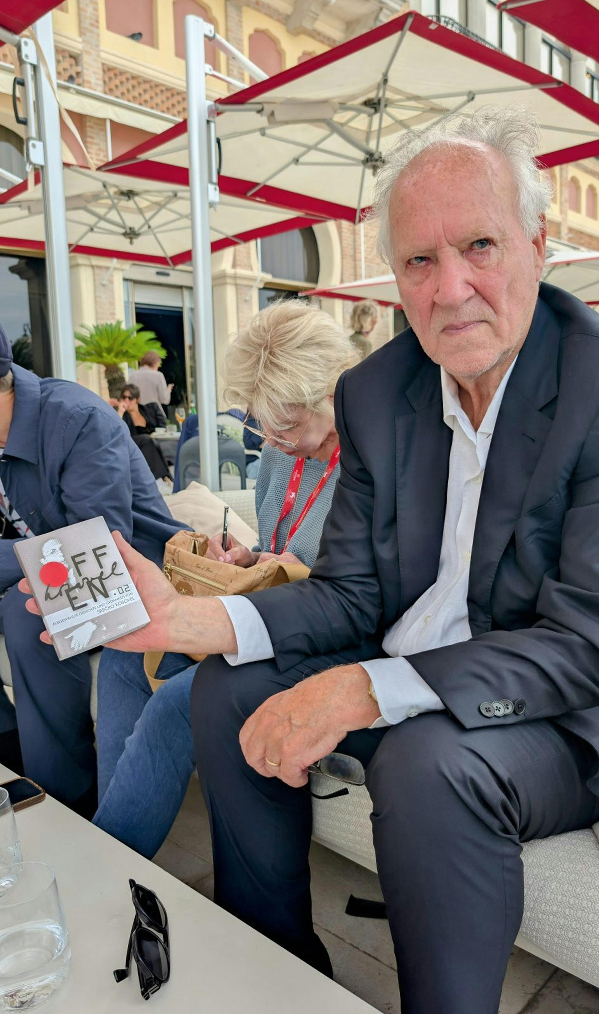 Herzog v kavarni, v rokah drži Kosovelovo knjigo