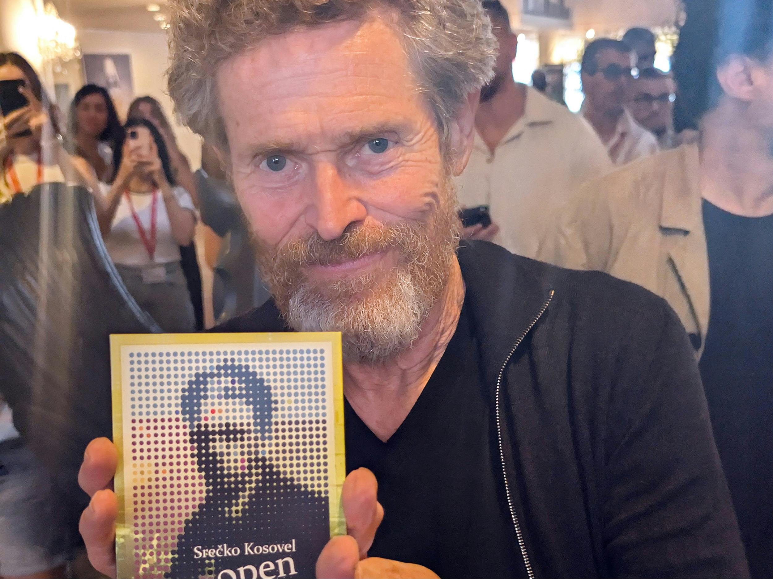Willem Dafoe s Kosovelovo knjigo v rokah