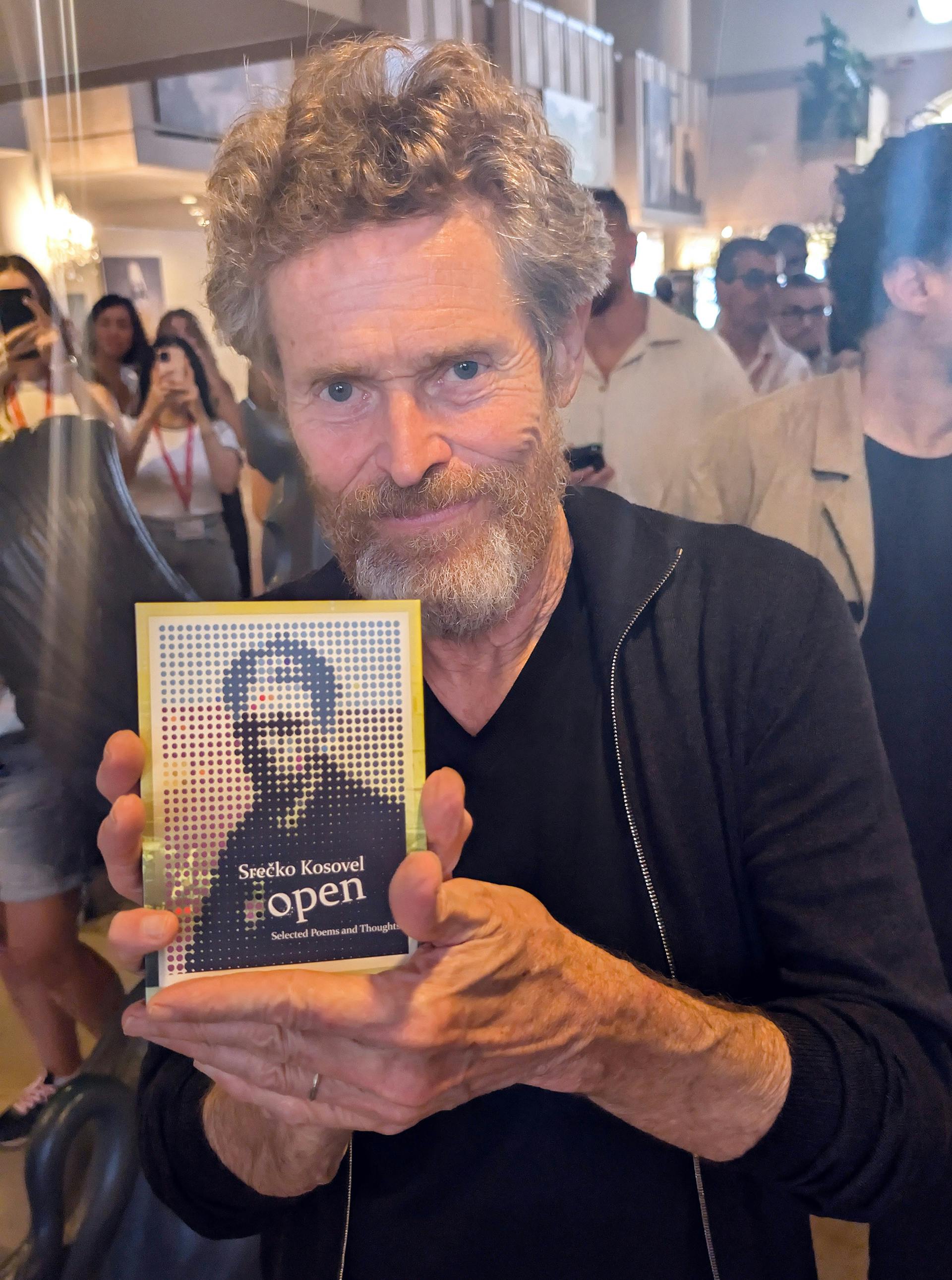 Willem Dafoe s Kosovelovo knjigo v rokah