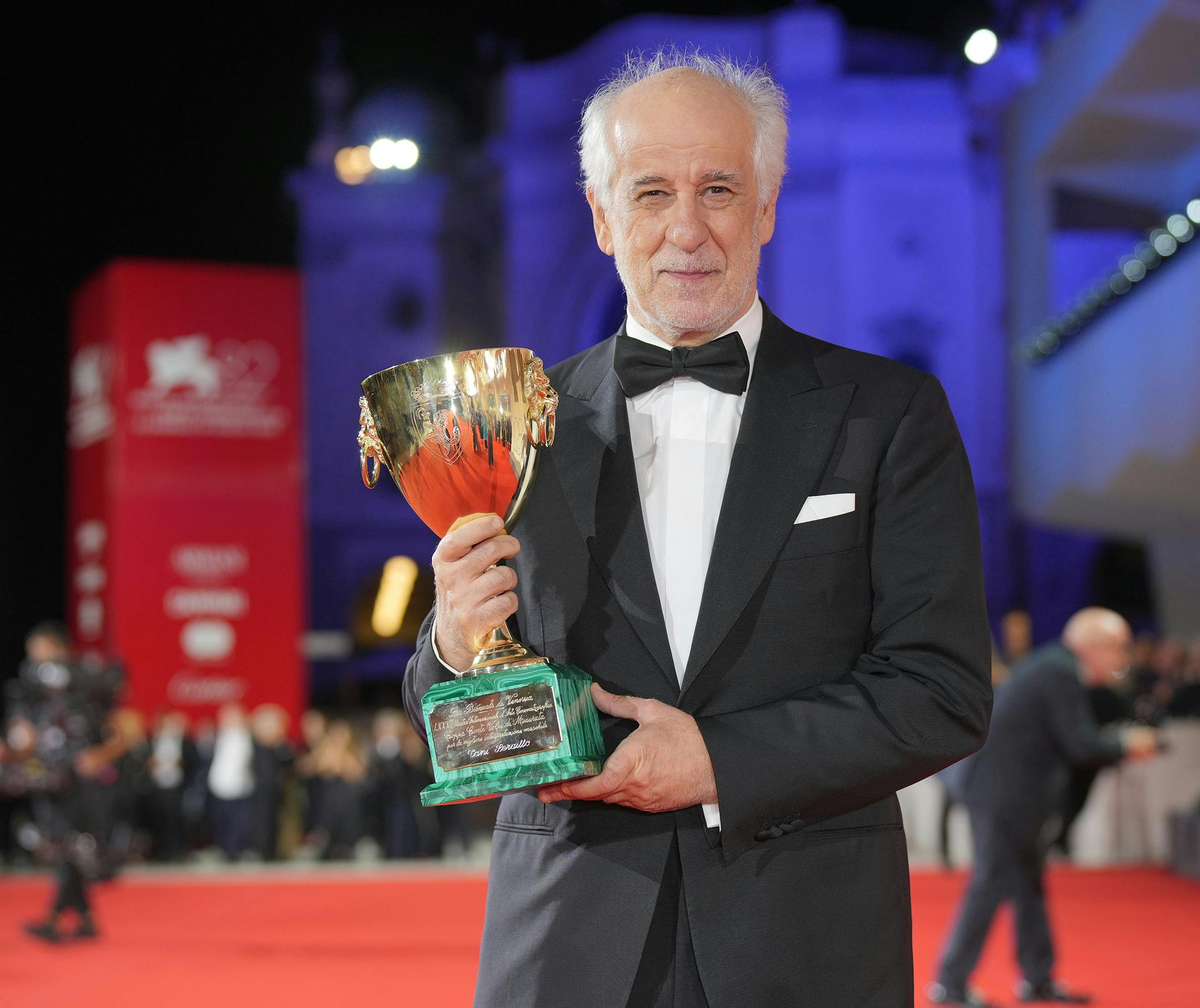 Toni Servillo na rdeči preprogi z nagrado v rokah