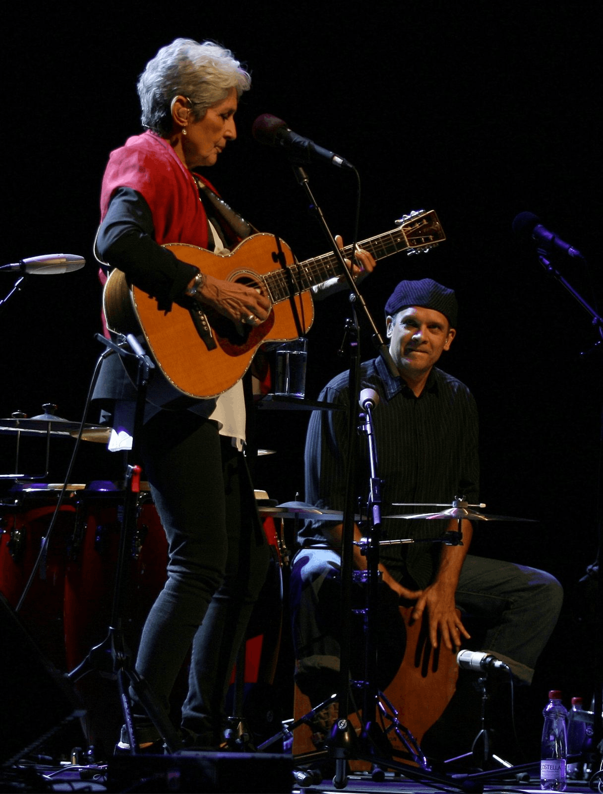 Joan Baez s kitaro na odru, Gabriel Harris je za njo na kahonu