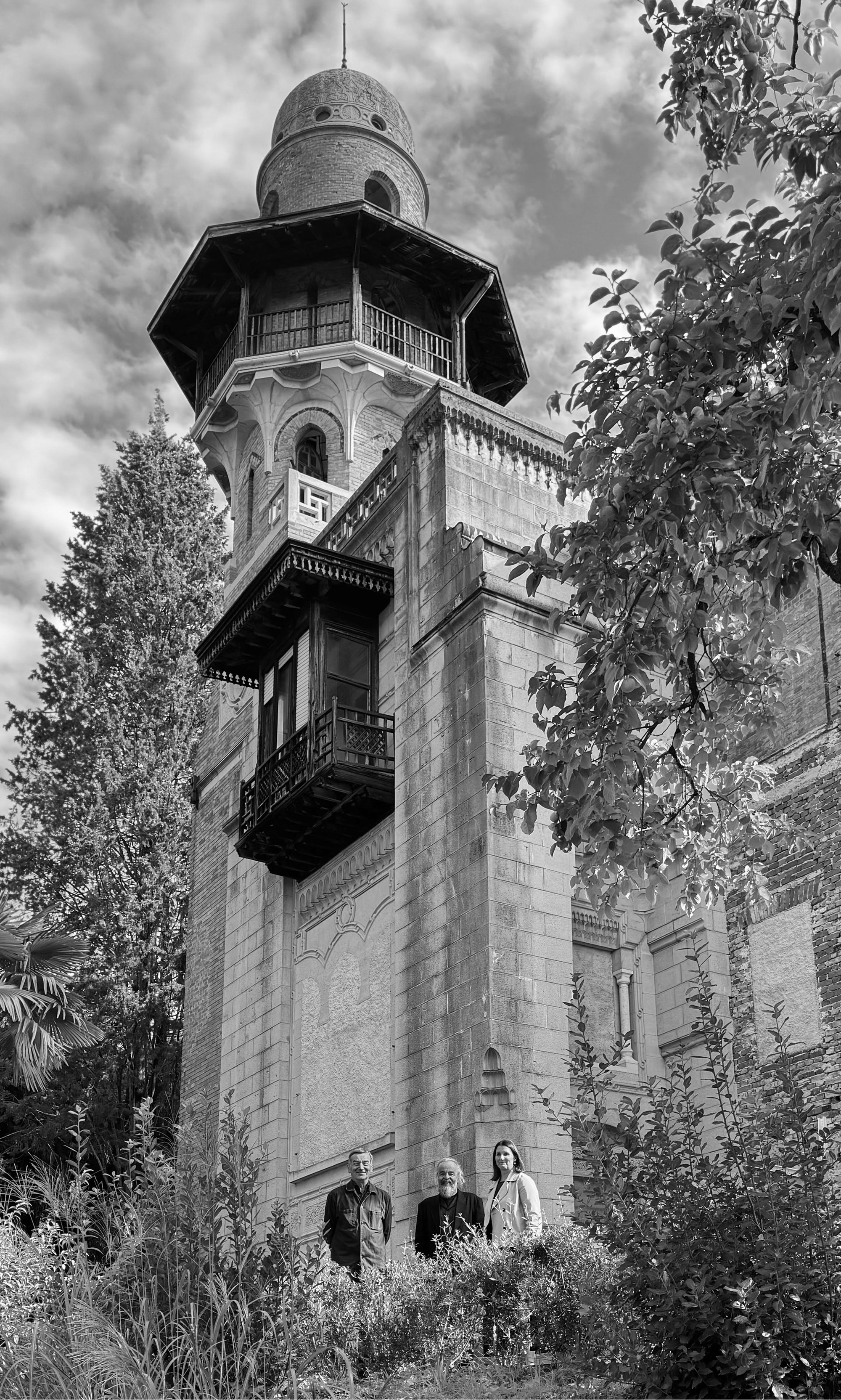 Črno-bela fotografija Vile Rafut s tremi obiskovalci pred njo