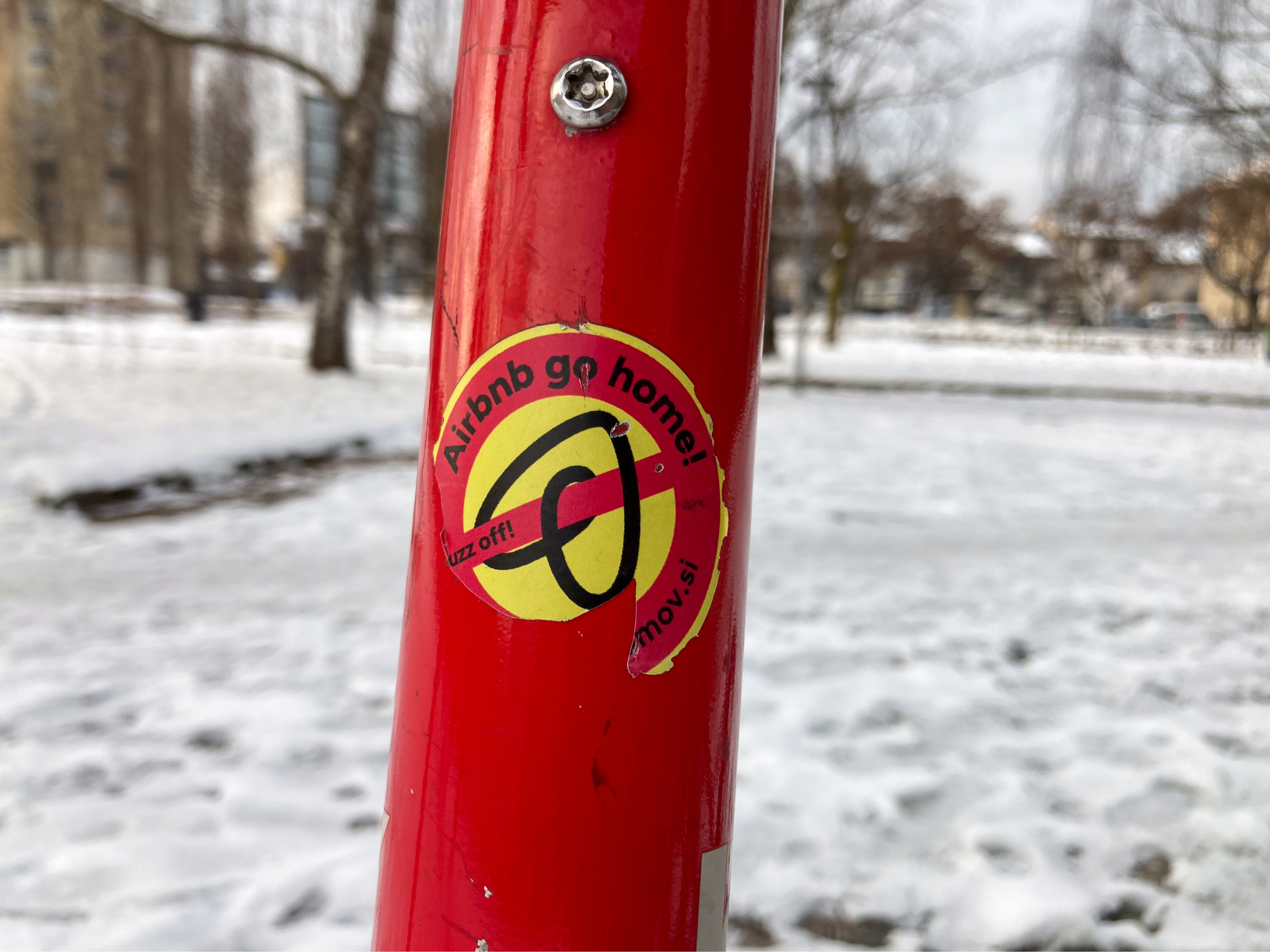 Nalepka z napisom Airbnb go home na drogu