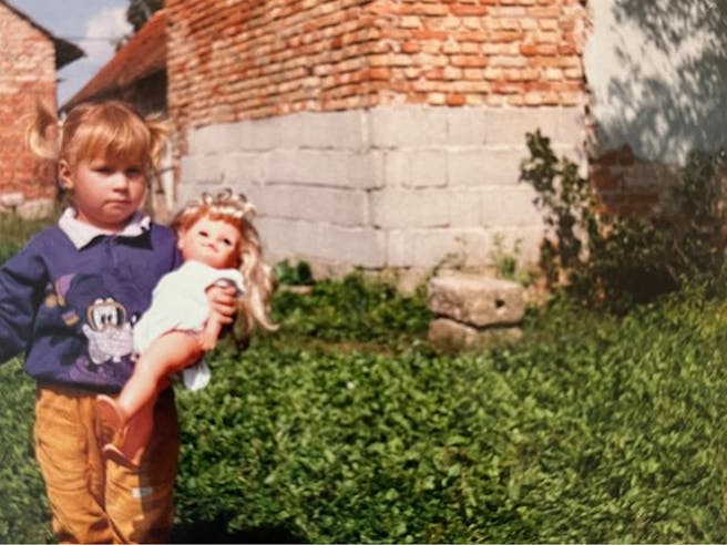 Mlada deklica z lutko v rokah