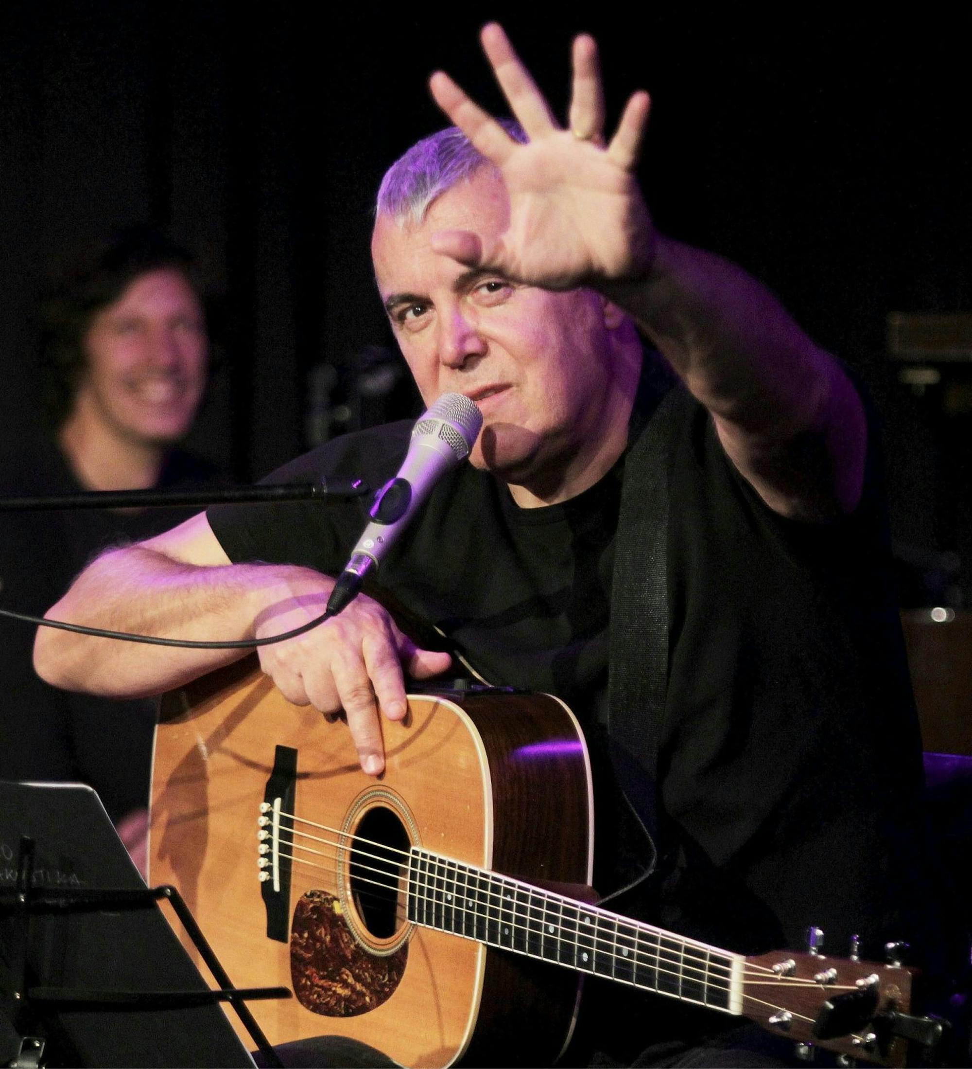 Zoran Predin na odru s kitaro v rokah