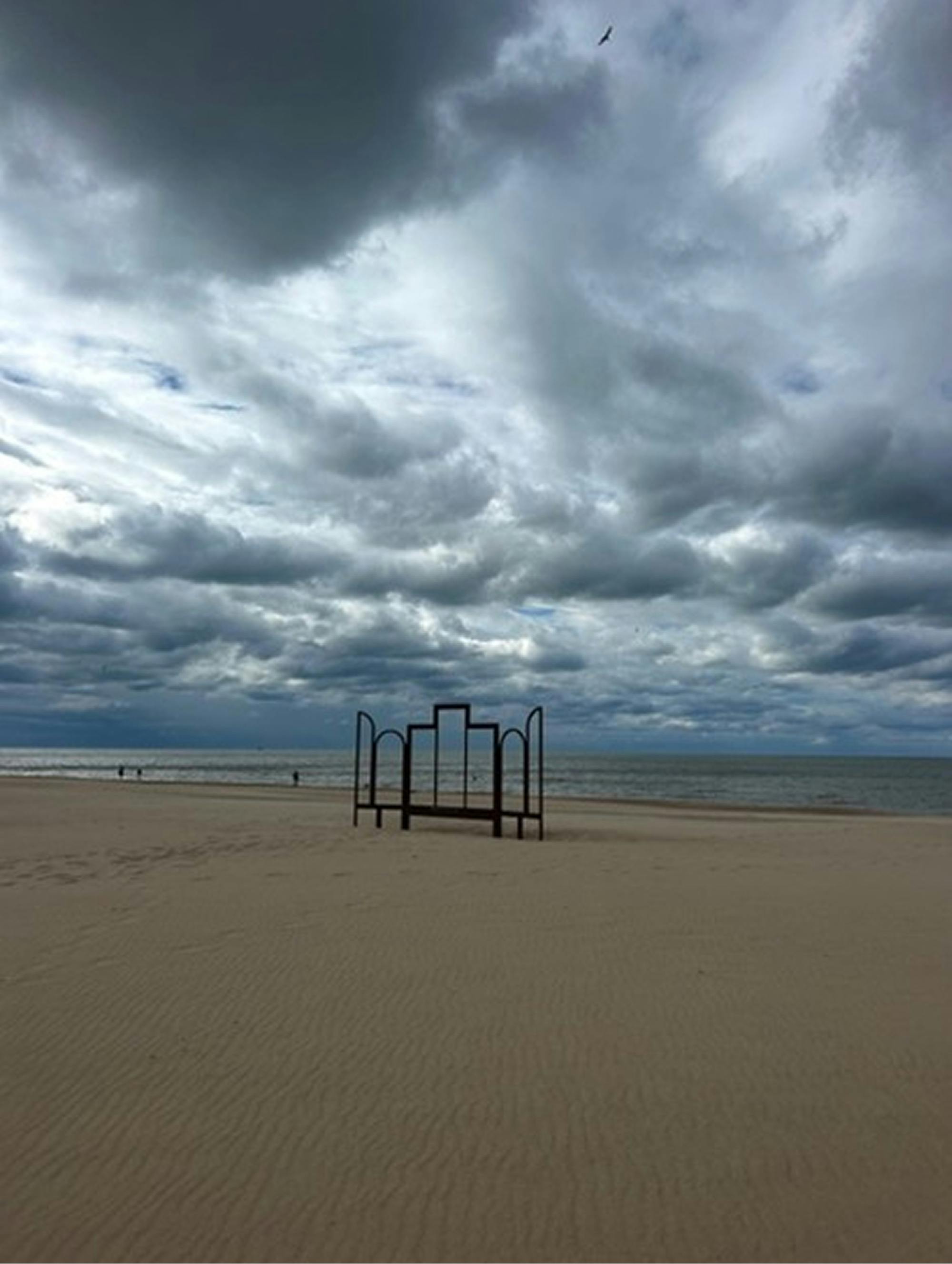 Peščena obala, nad katero so temni oblaki