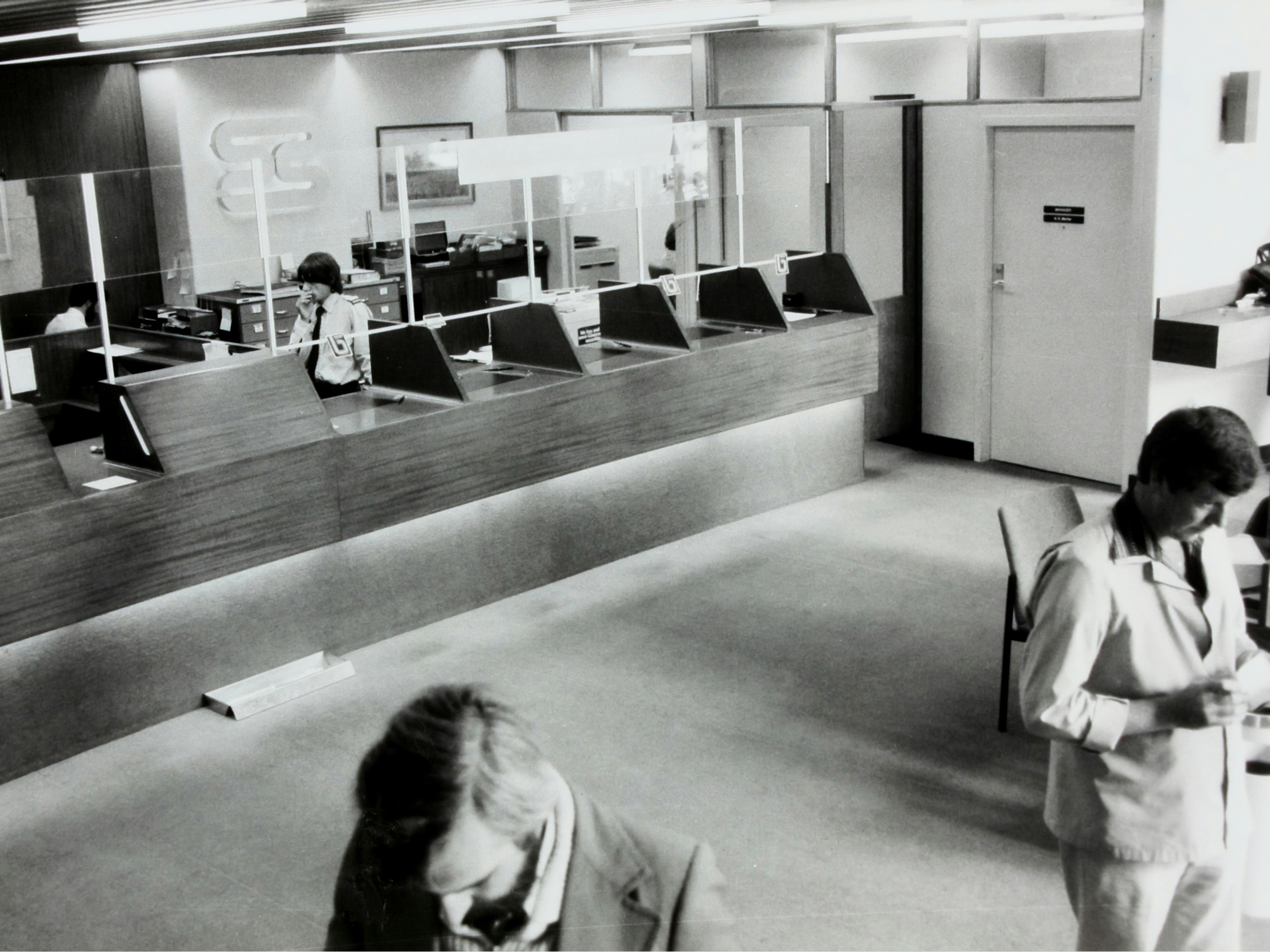 Črno-bela fotografija čakalnice pred okenci