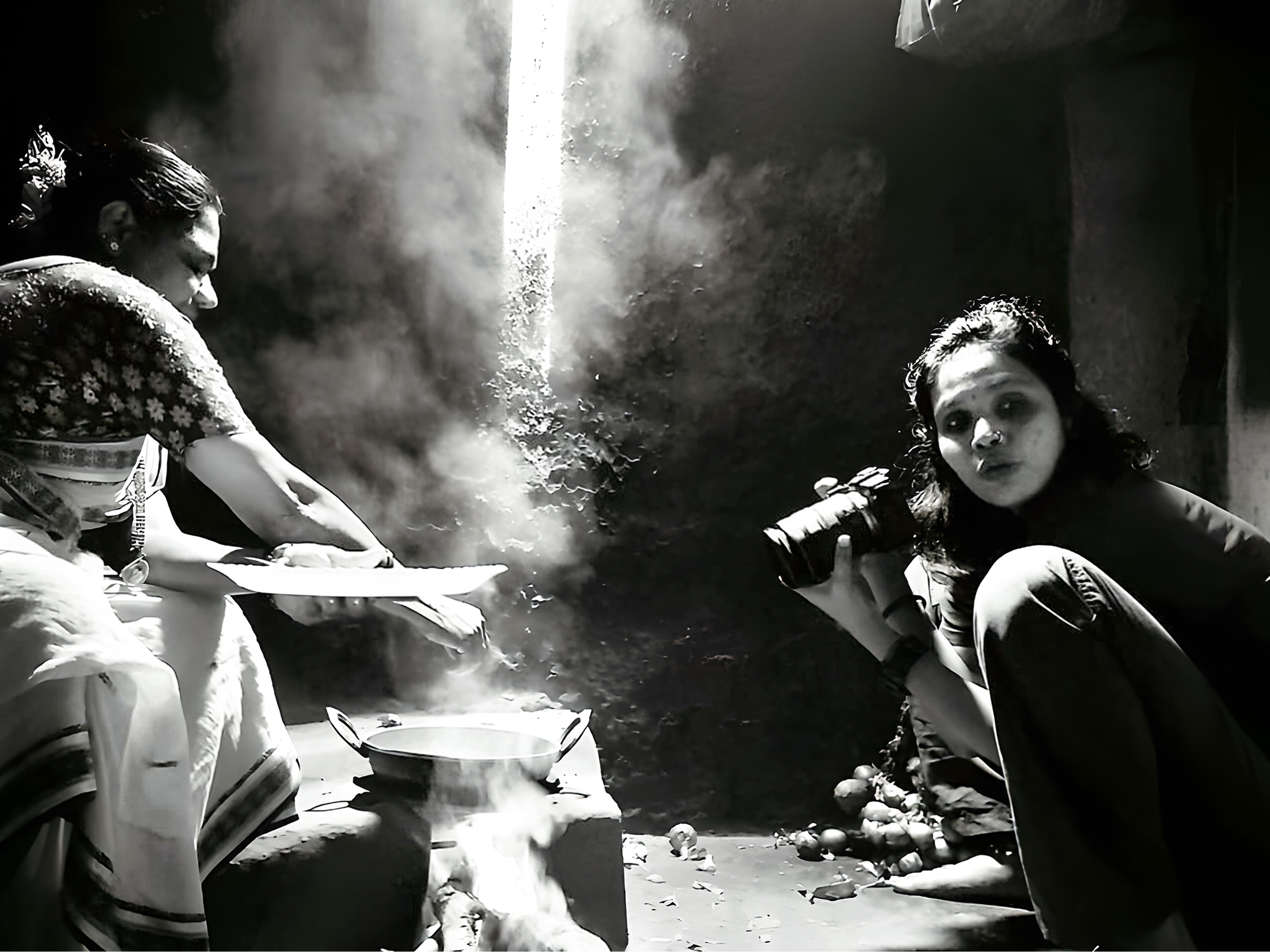 Ženska s fotoaparatom, ki fotografira drugo, ki kuha