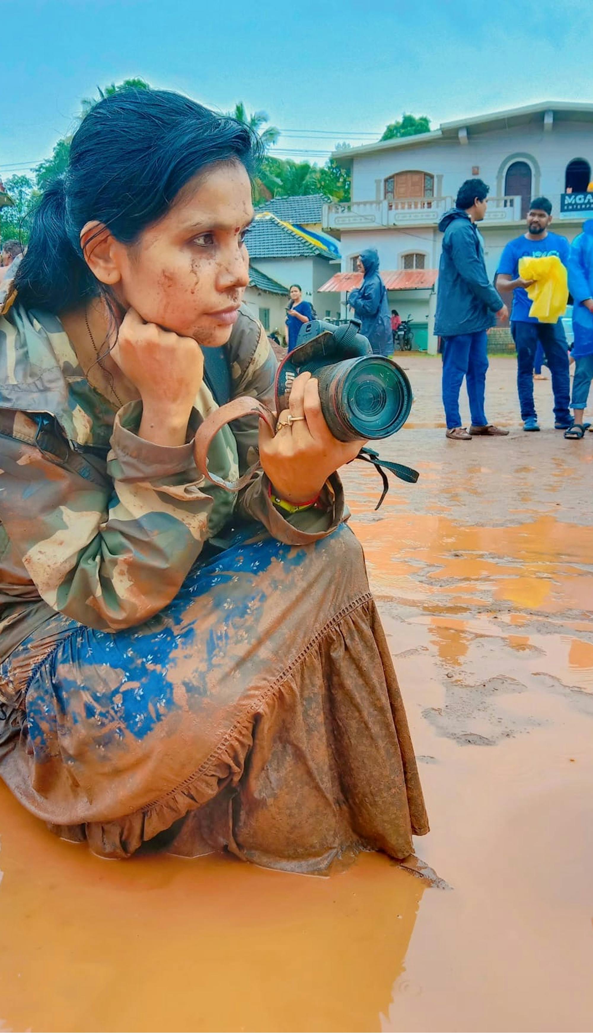 Avtorica knjige, ki stoji v blatu s fotoaparatom v rokah