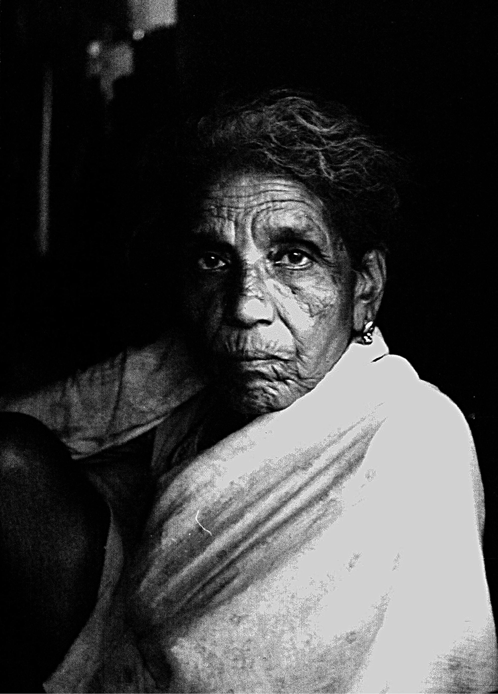 Črno-bela fotografija starejše indijke, ovite v blago