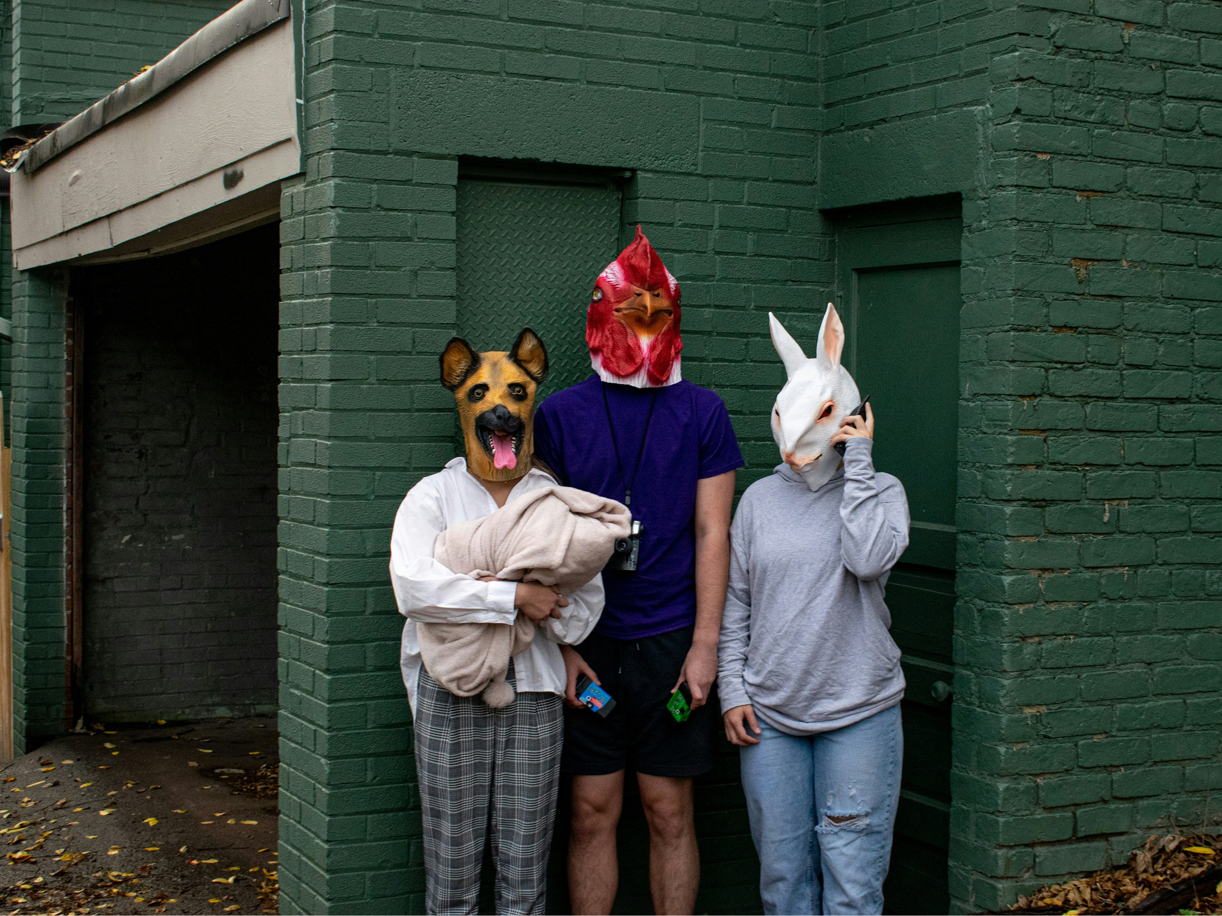 Trije ljudje z maskami živali čez glavo